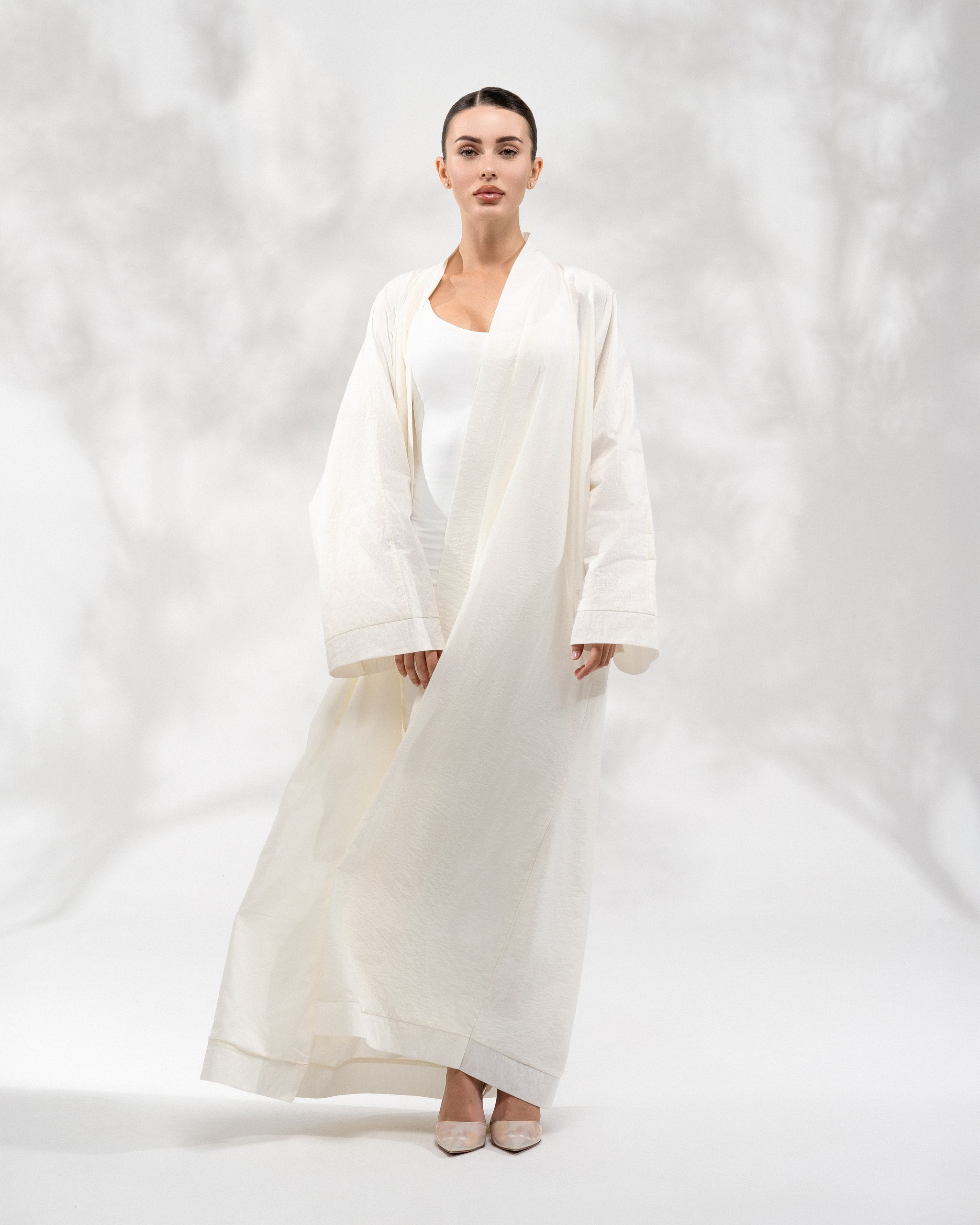 Minimalist studio fashion photography featuring a white abaya with soft lighting
