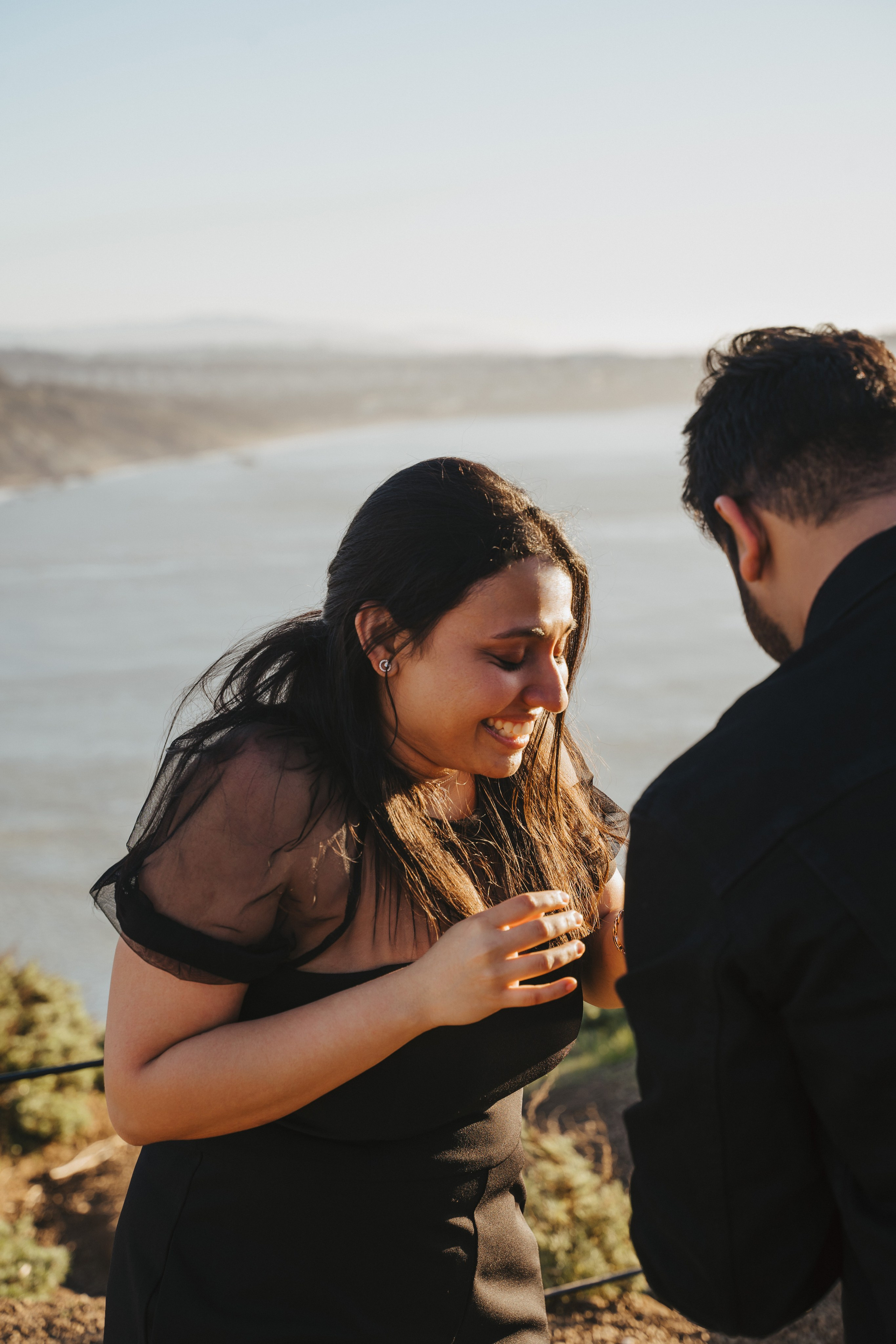 Proposal.  Overlooking the golden San Franisco Bridge sunset with a couple. Photographer Video. 