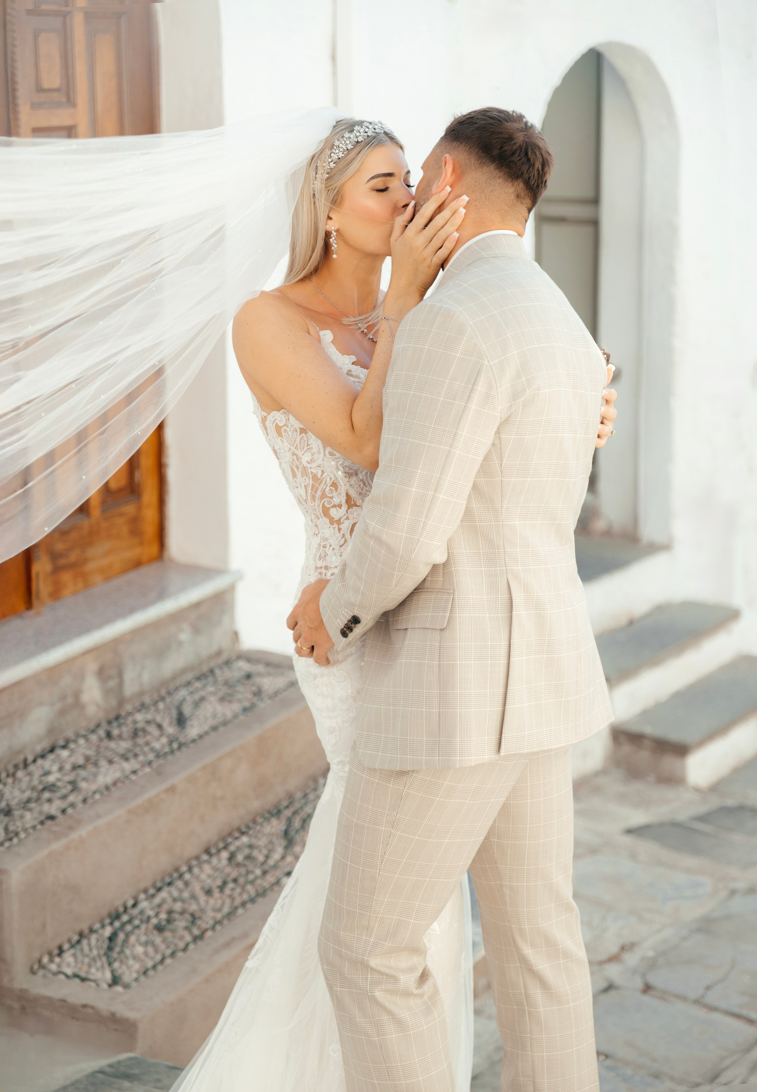 Bride and groom enjoying a quiet moment together on a cobblestone street in Lindos, with traditional Greek architecture around them