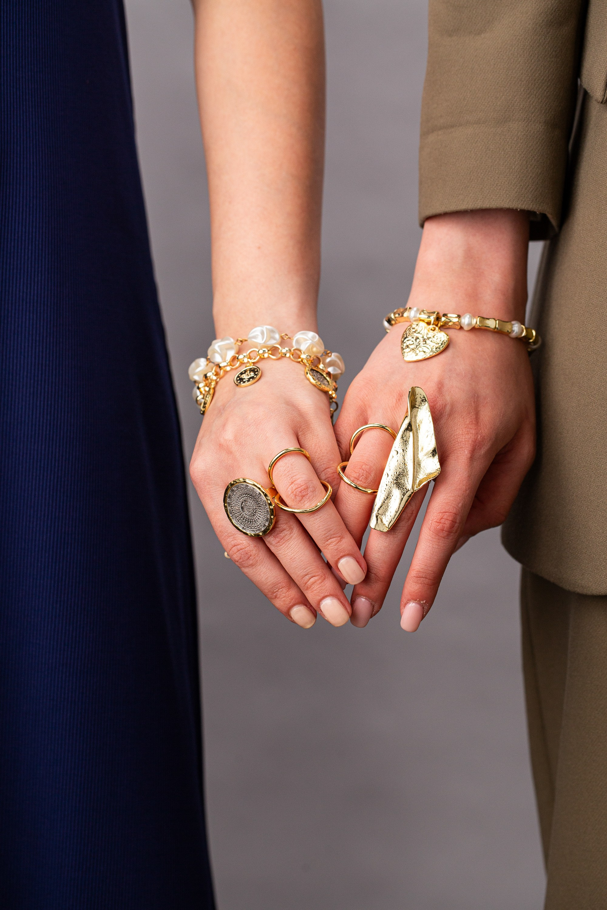 İki nəfərin əlləri bir-birinə bağlanaraq, uyğun qızıl zinət əşyalarını göstərir. Aksessuarlara mirvari və ürək bilərziklər və böyük, abstrakt formalı üzüklər daxildir.