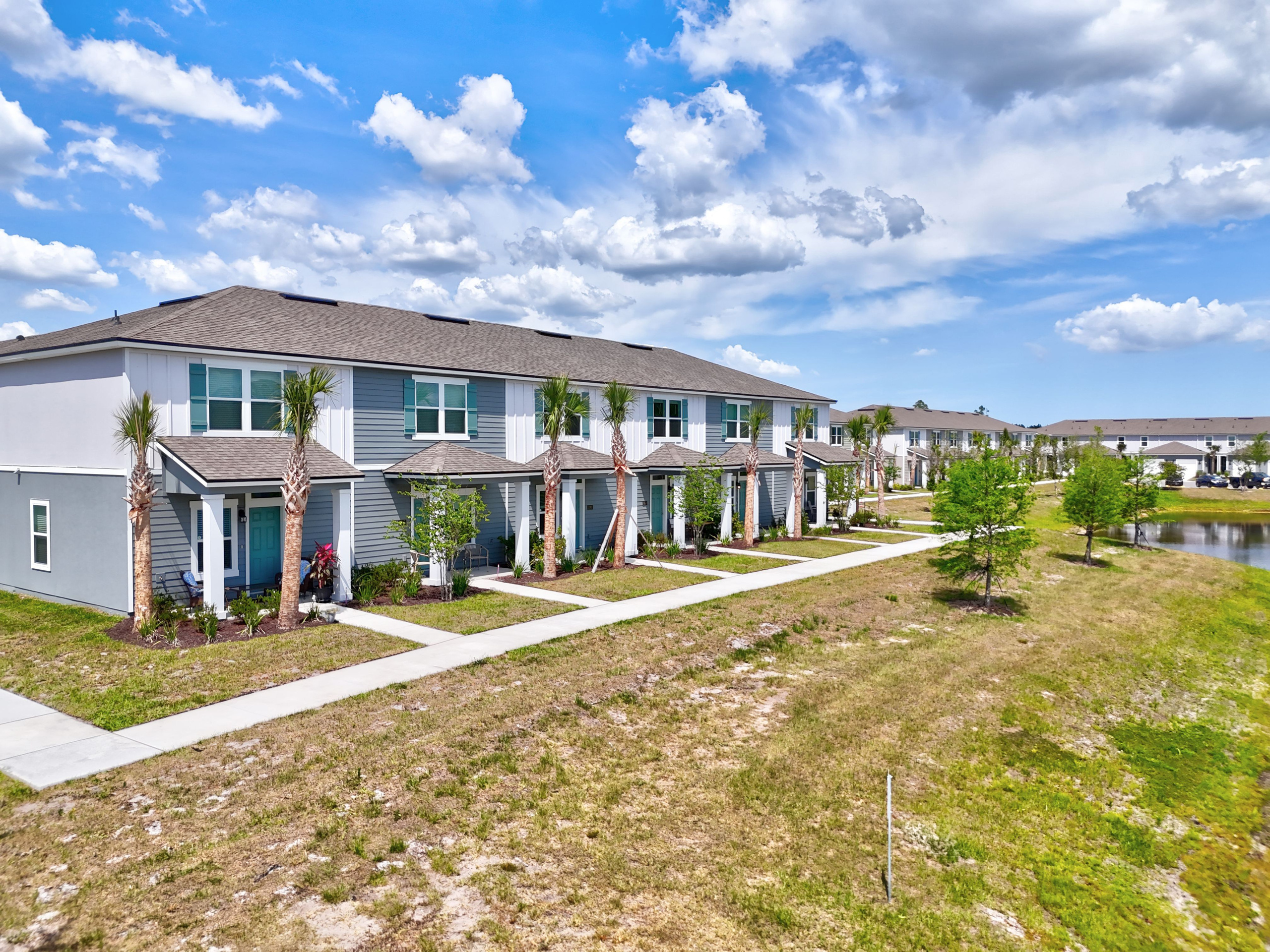 Newly built townhouse community under bright blue sky