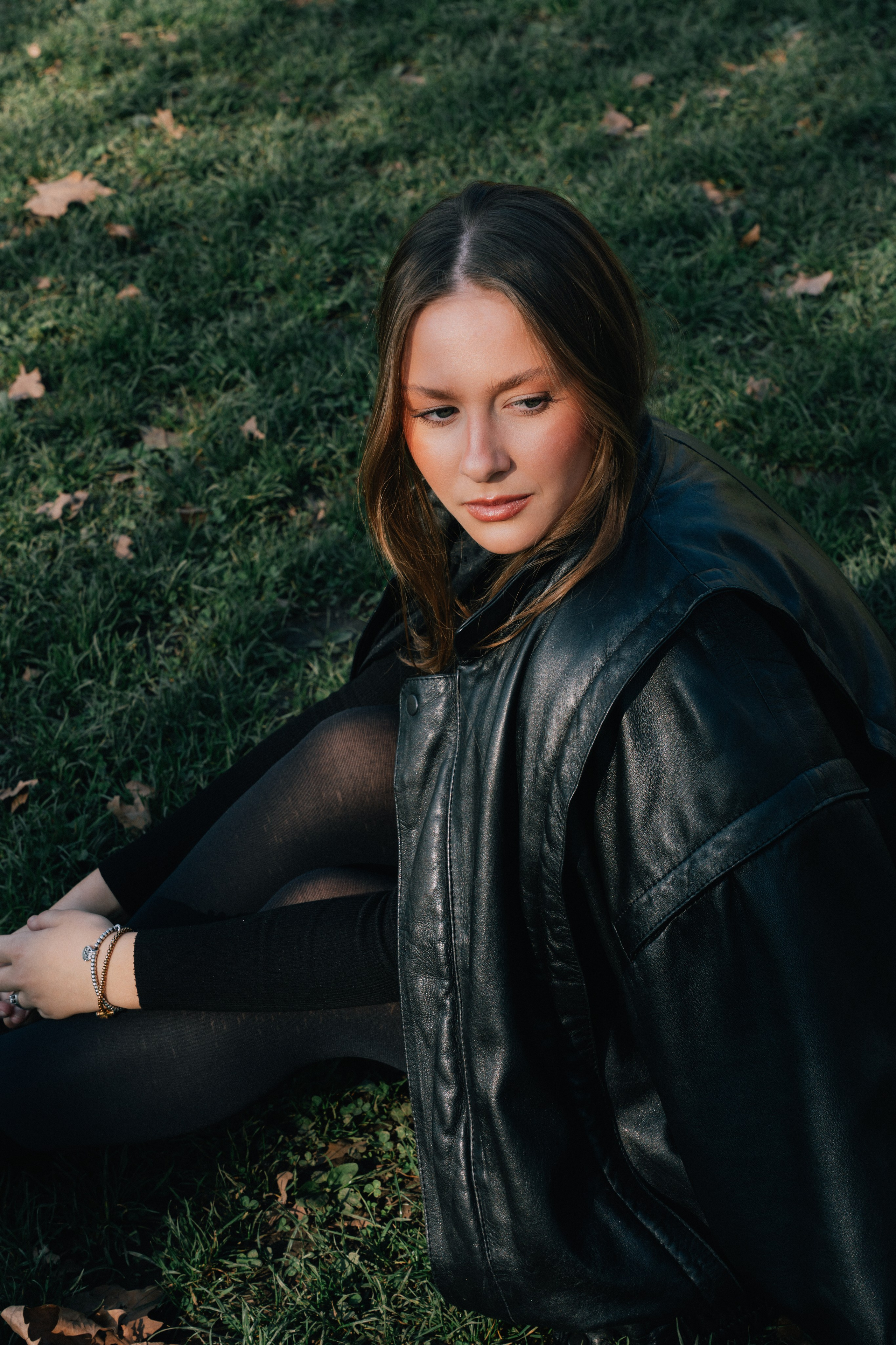 девушка сидит на траве в парке в Милане во время фотосессии 