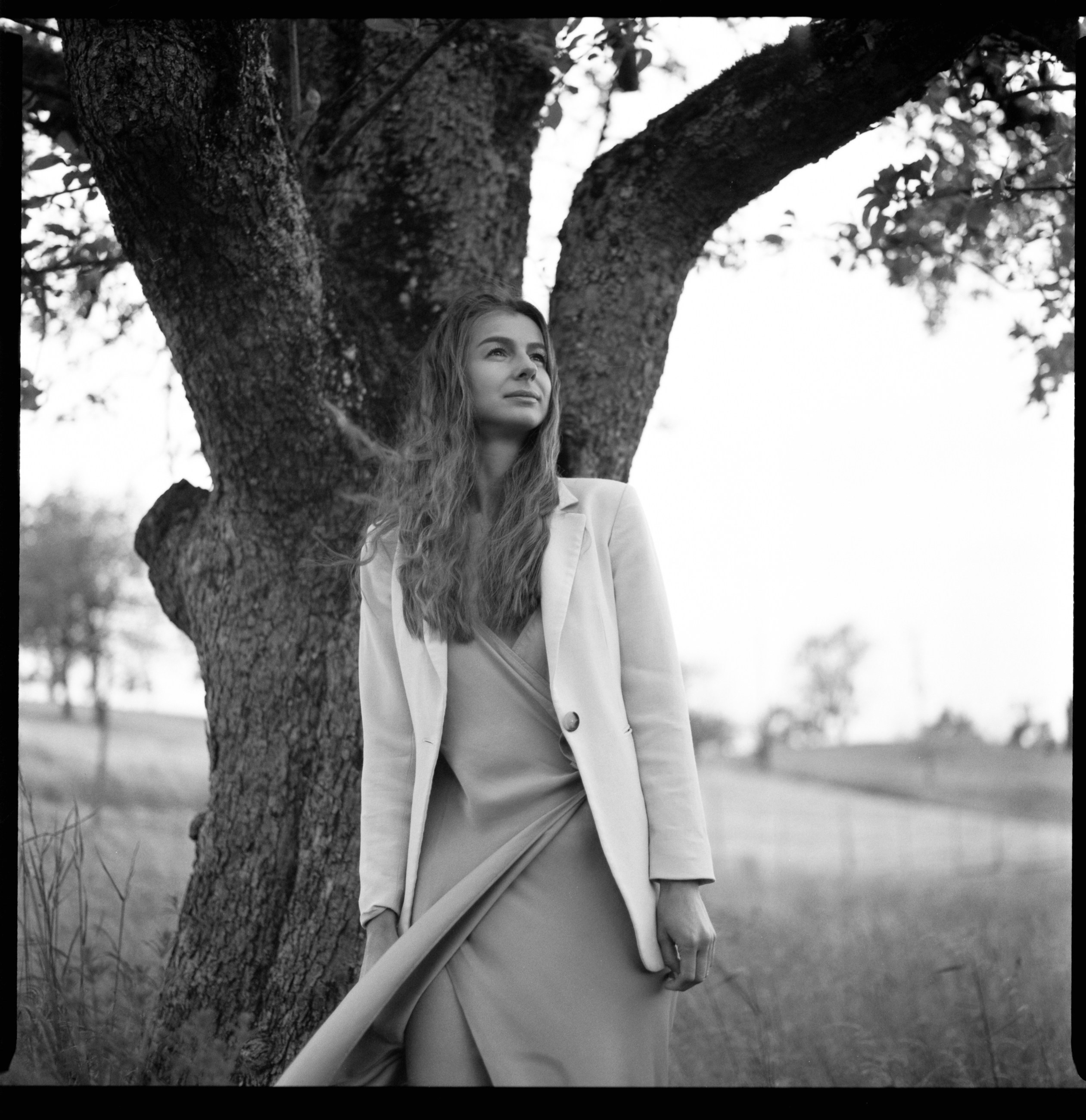 Portrait of a woman by a tree in soft light, shot on medium format analog film near Lindau
