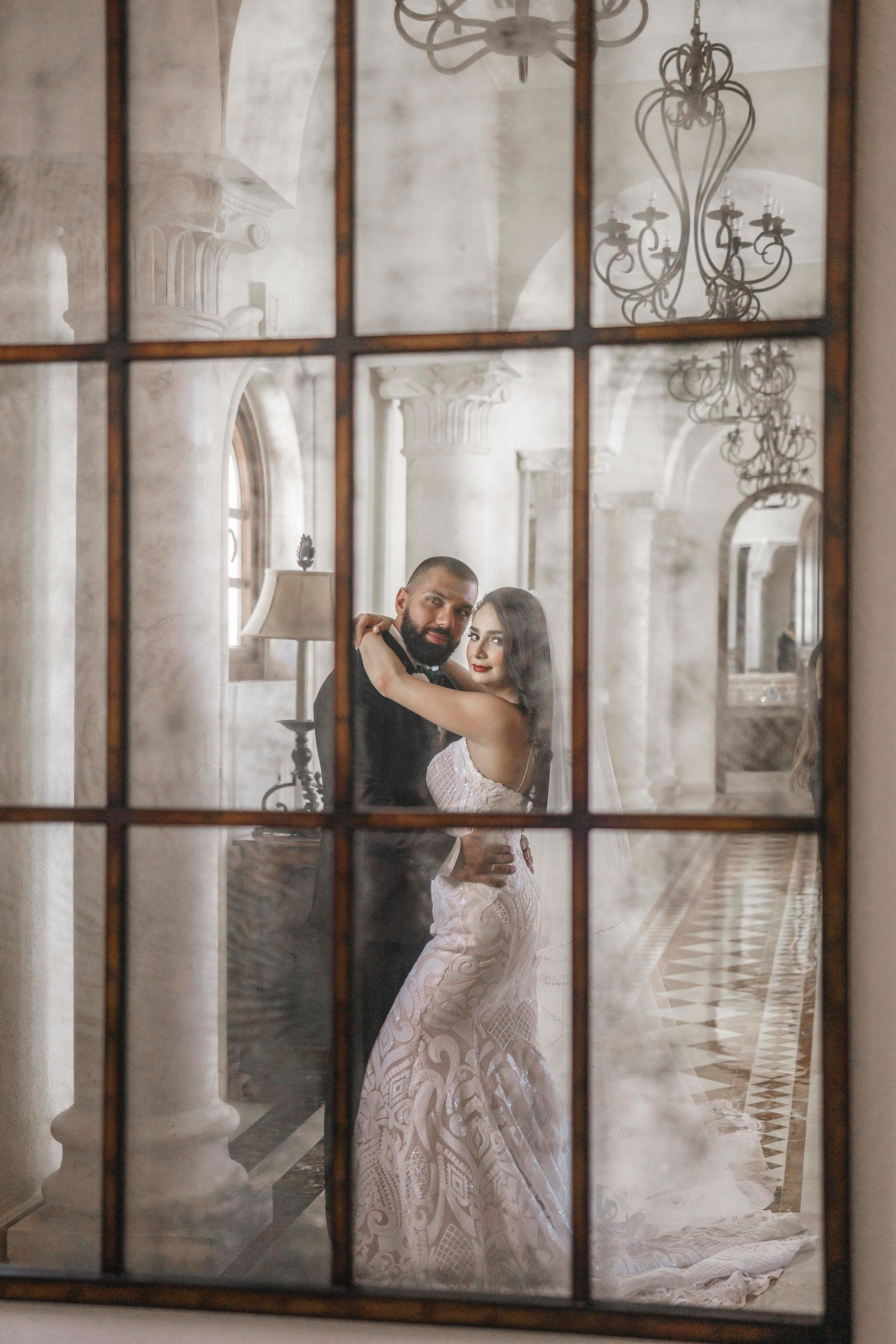 Bride and groom posing under arches in luxury Tulum wedding venue