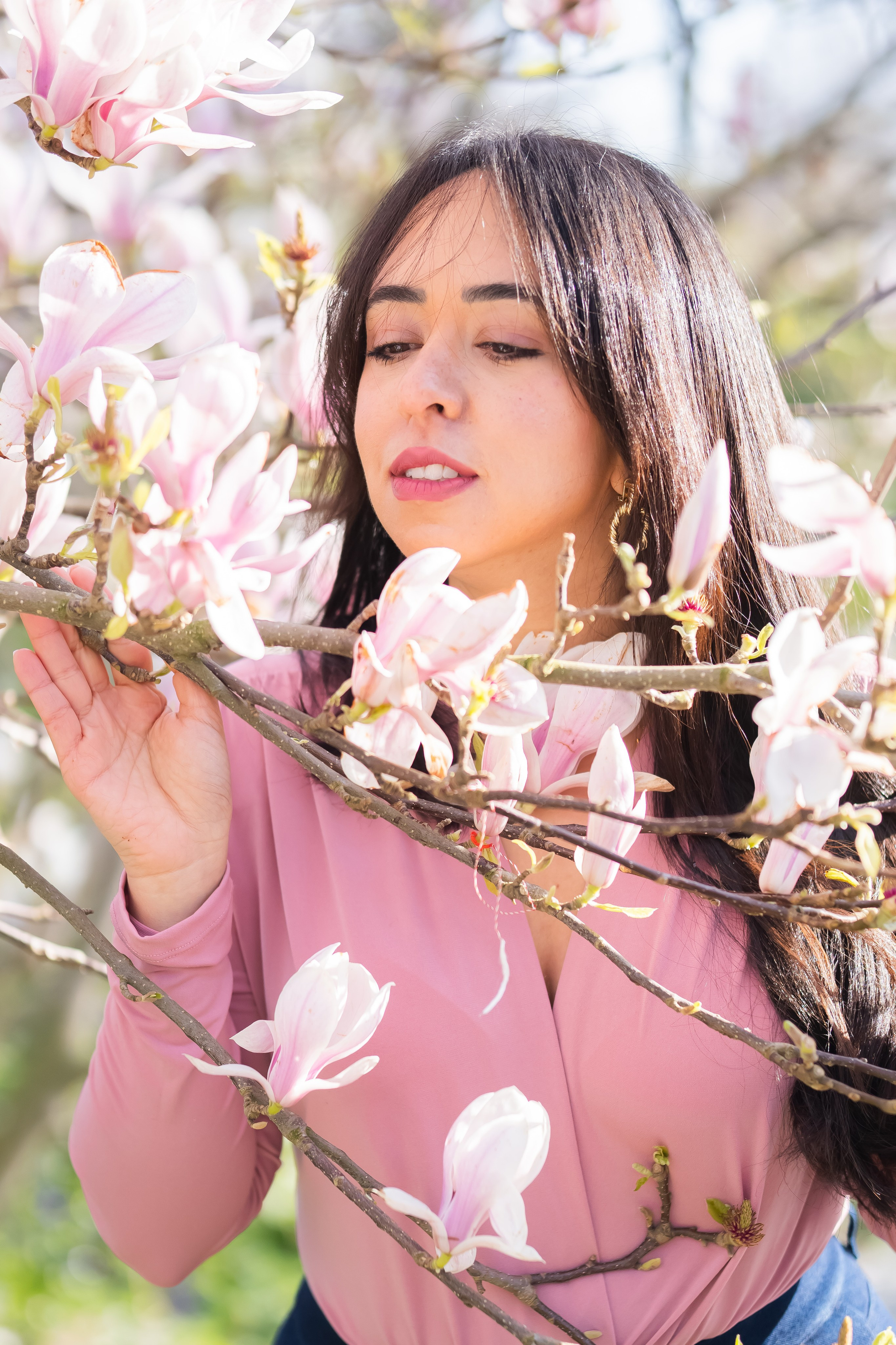 girl holding a magnolia branch in a garden in Netherlands