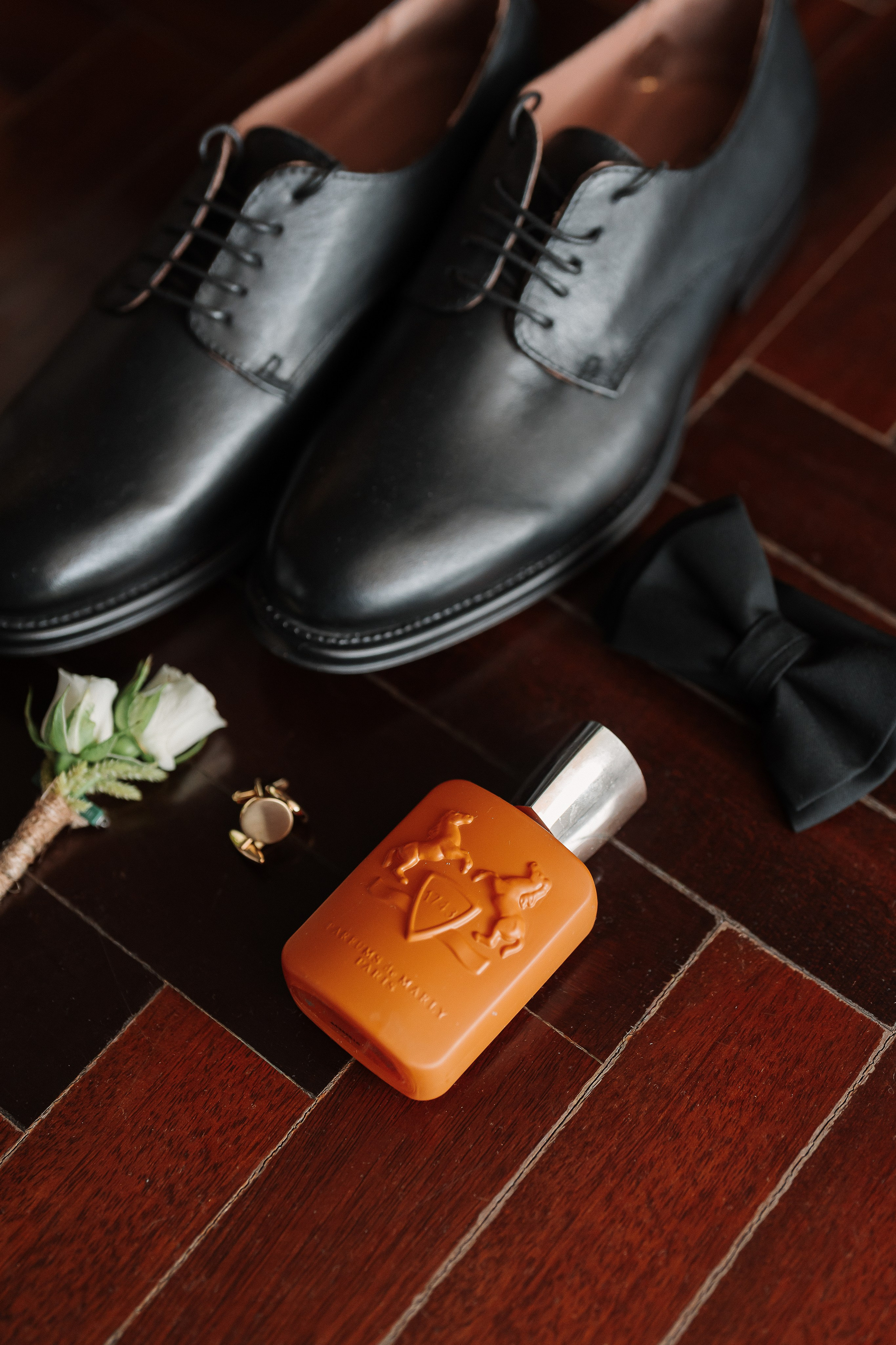 Sapatos, perfume e acessórios do noivo durante os preparativos do casamento