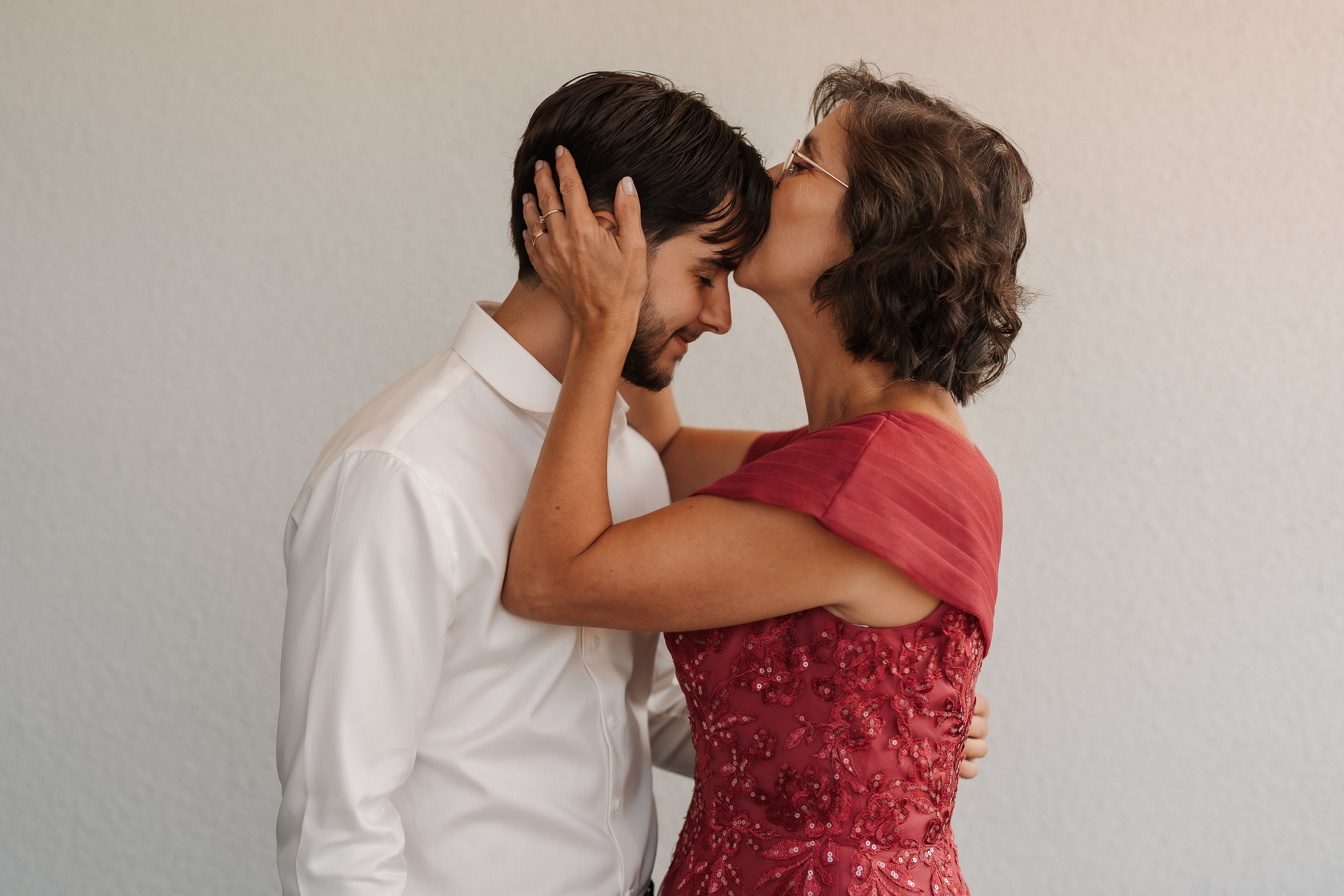 Mãe a beijar o noivo durante os preparativos do casamento