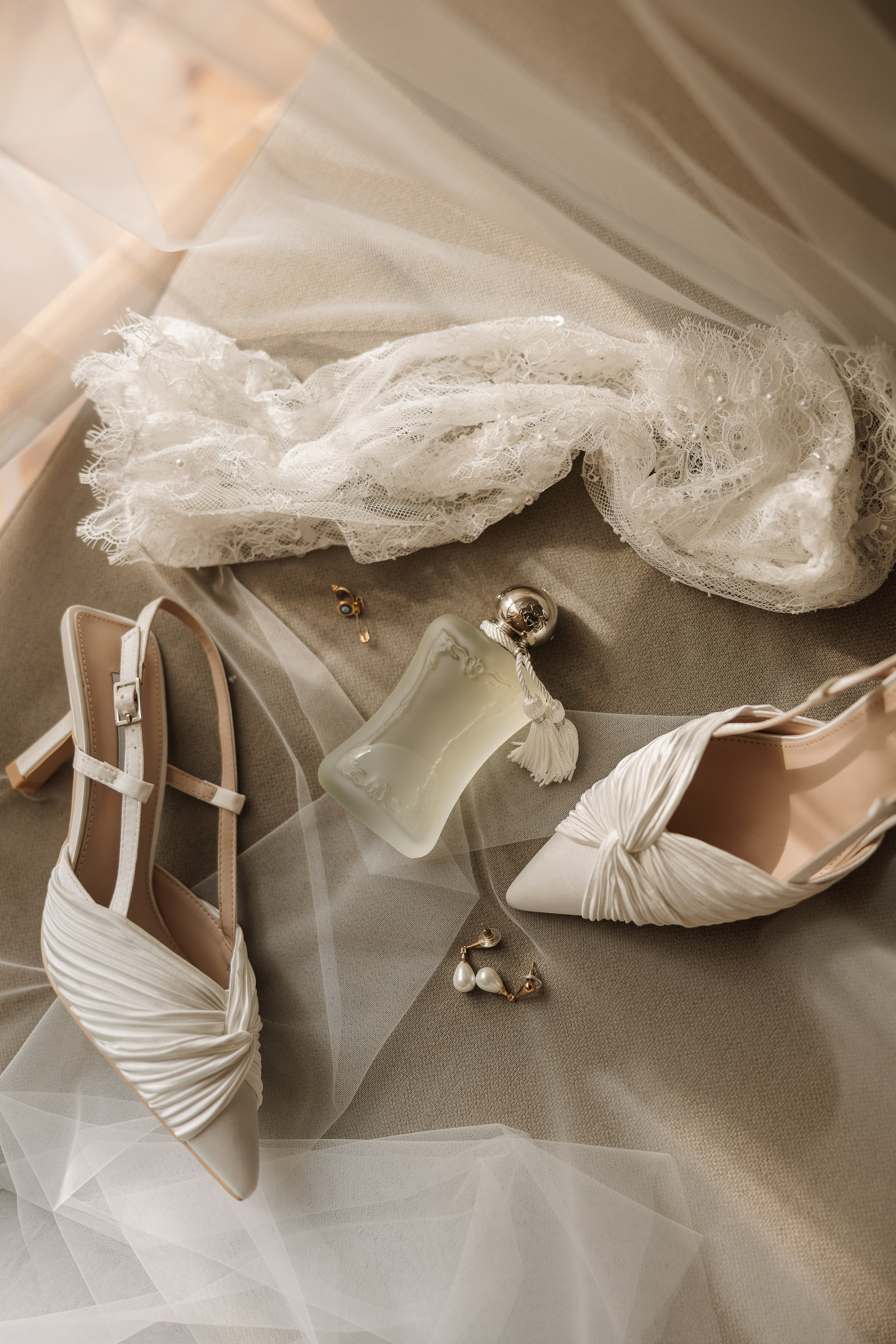 Sapatos e acessórios da noiva sobre o vestido de casamento