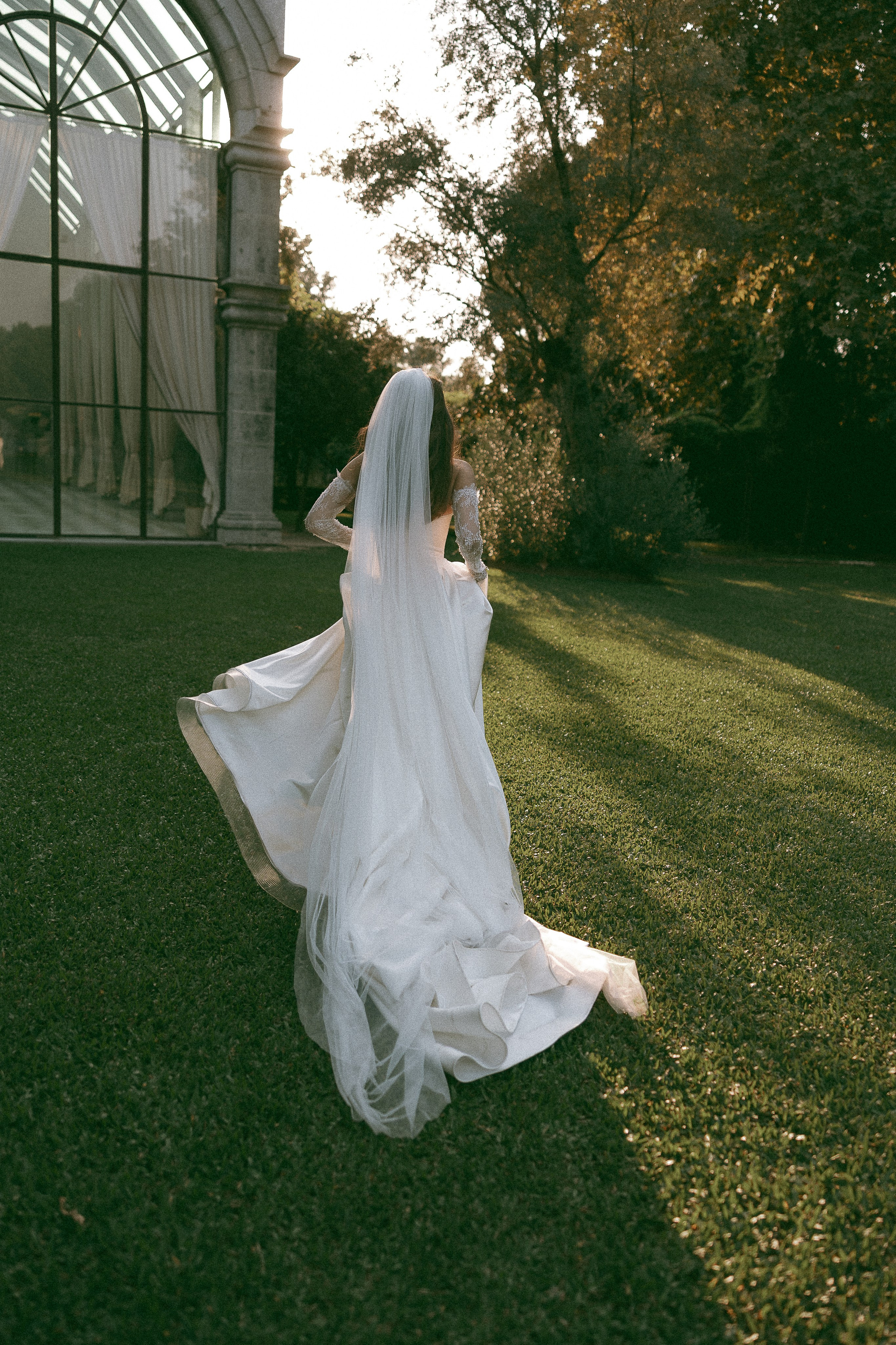 Noiva a caminhar pelo jardim com o vestido de casamento