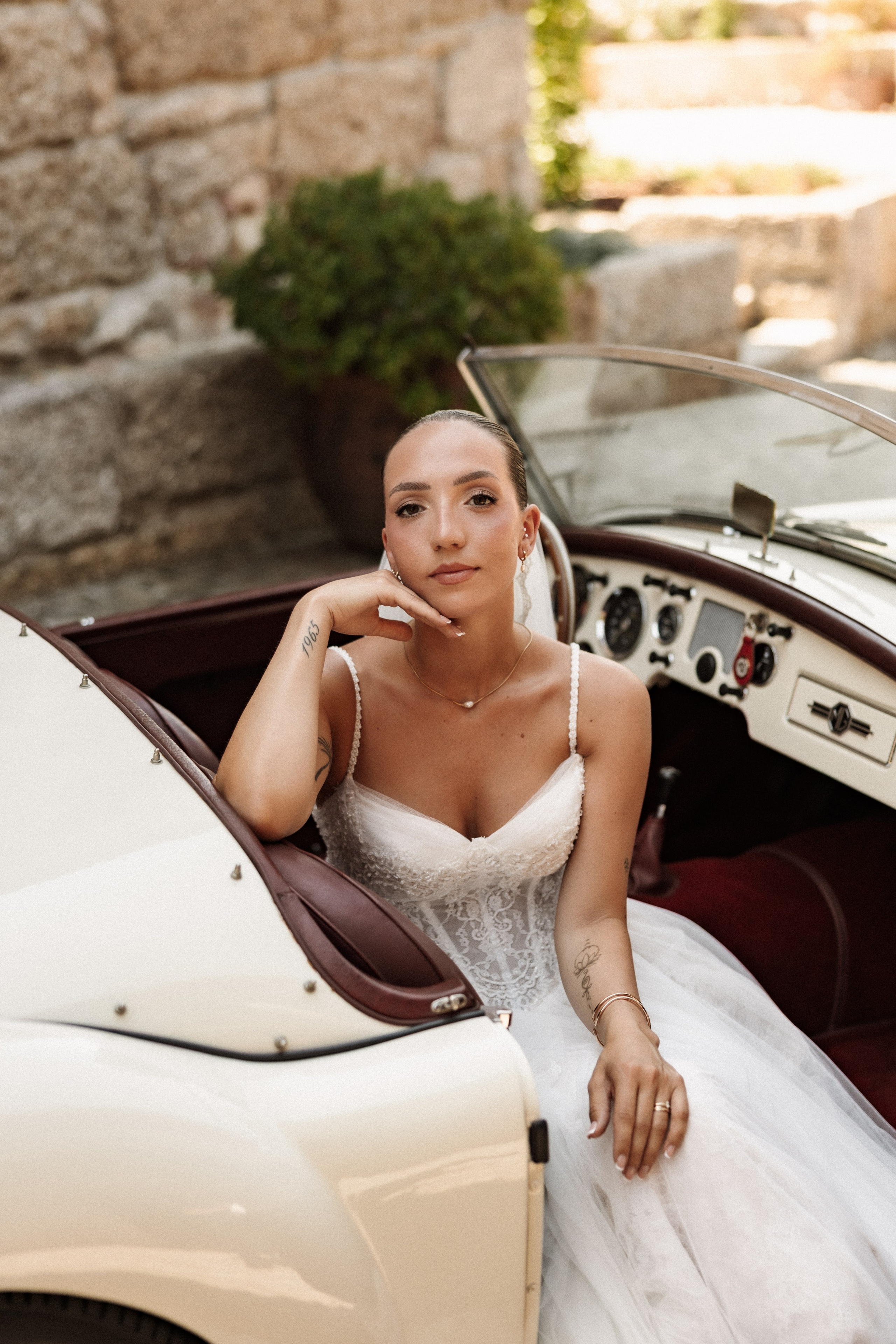 Portrait de la mariée près de la voiture ancienne