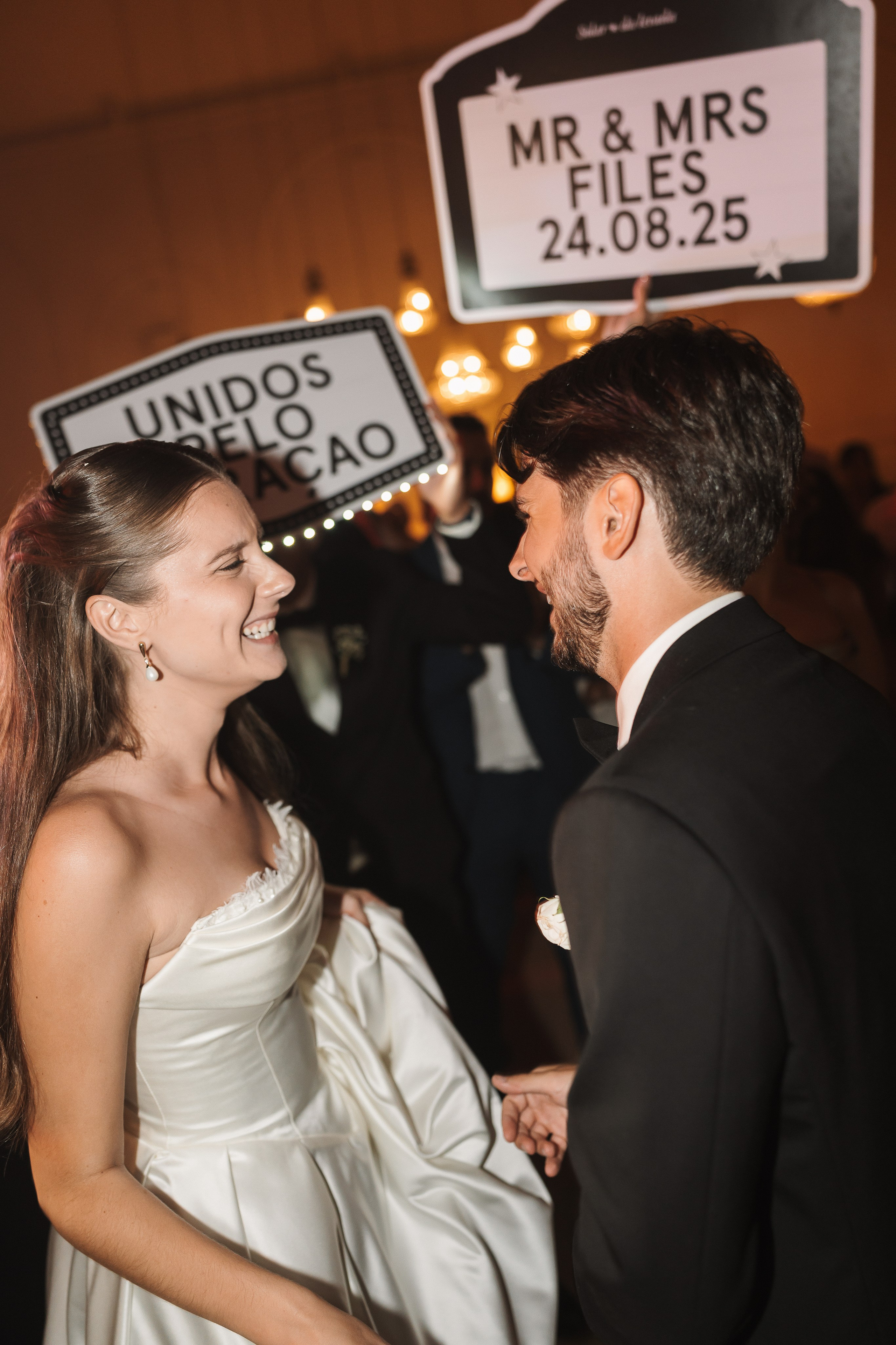 Noivos com placas personalizadas durante a festa de casamento