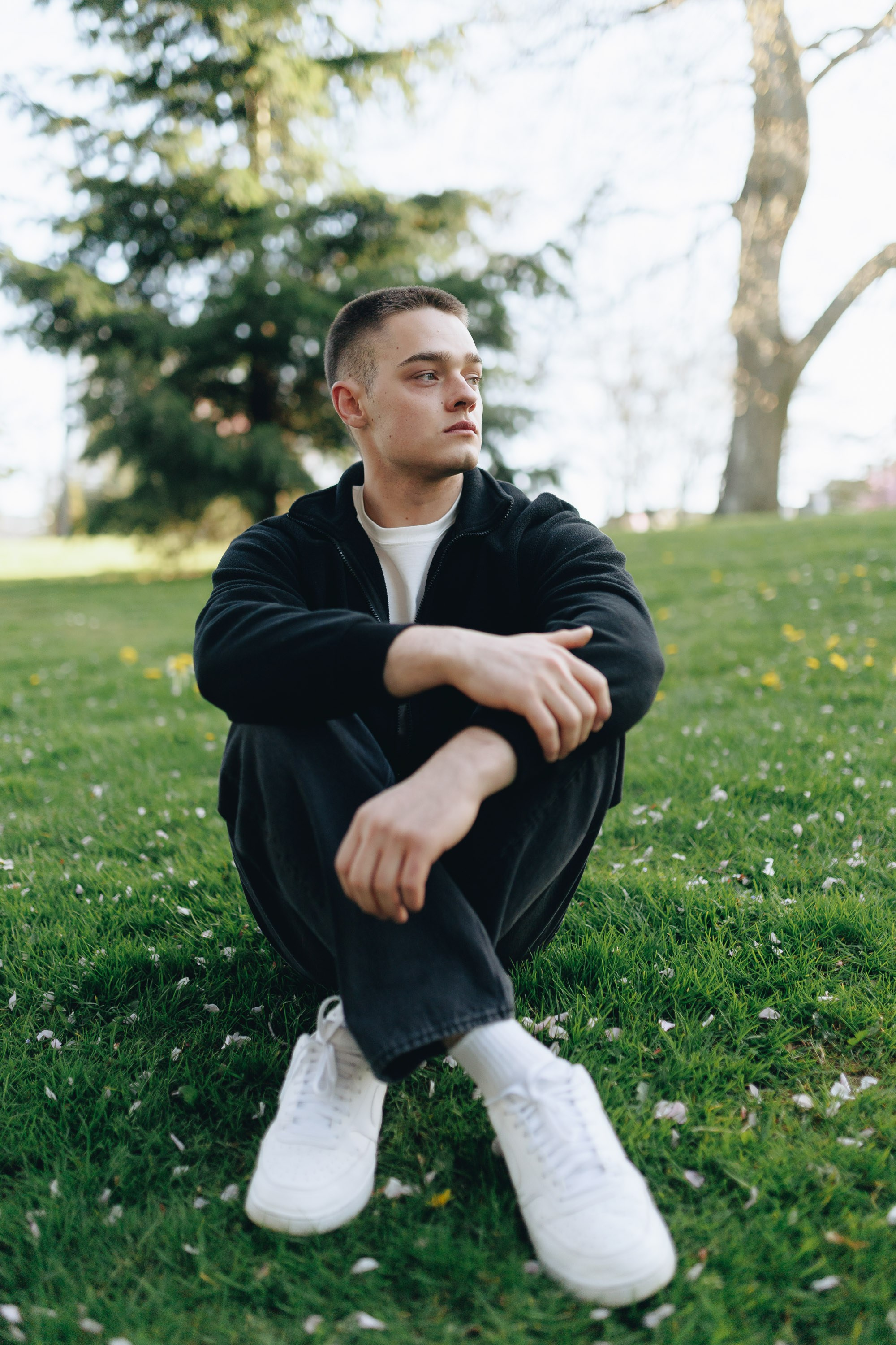 Man sitting on grass in casual pose, outdoor park