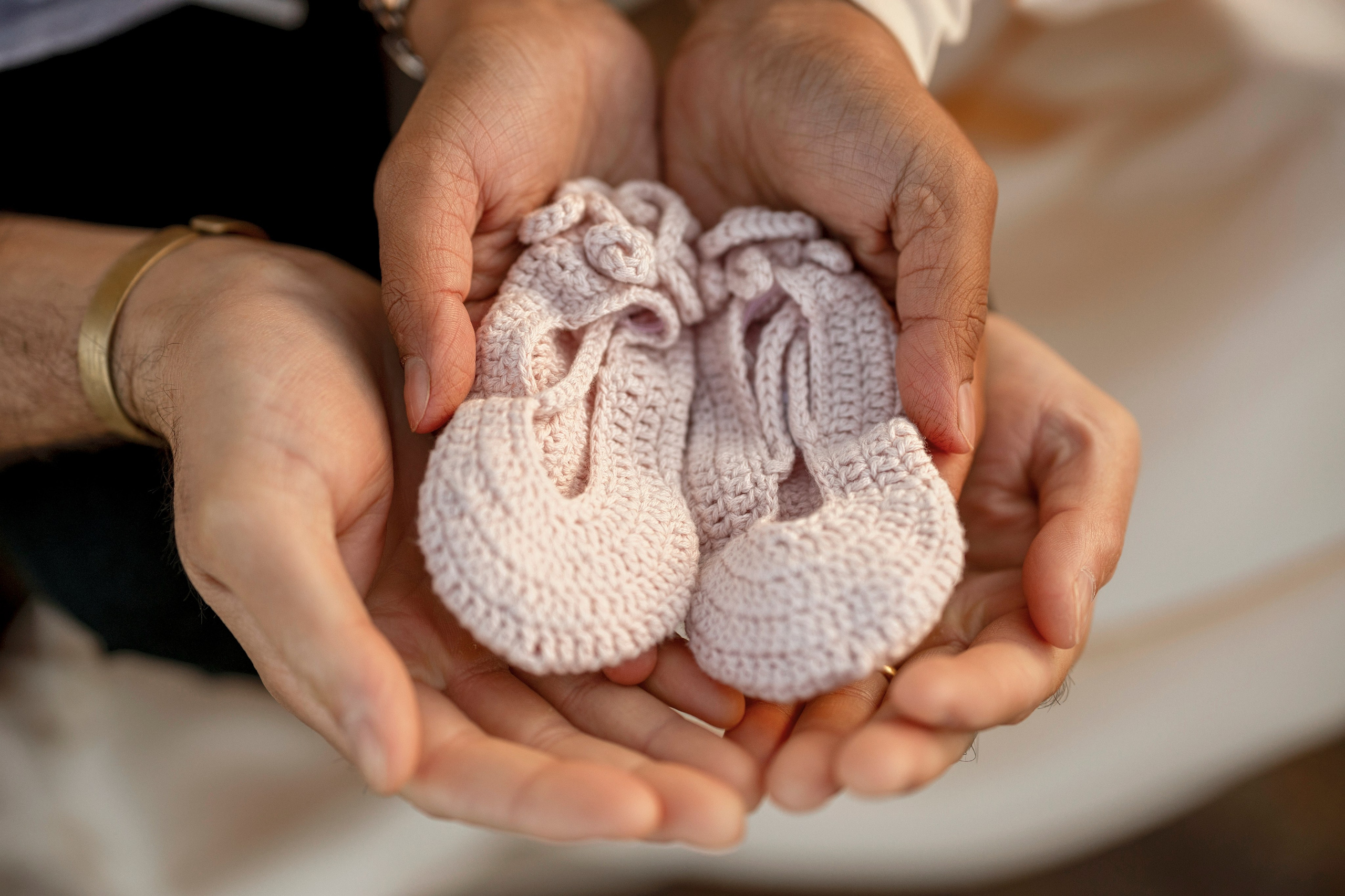 Expecting parents on beach during maternity session with soft sunlight