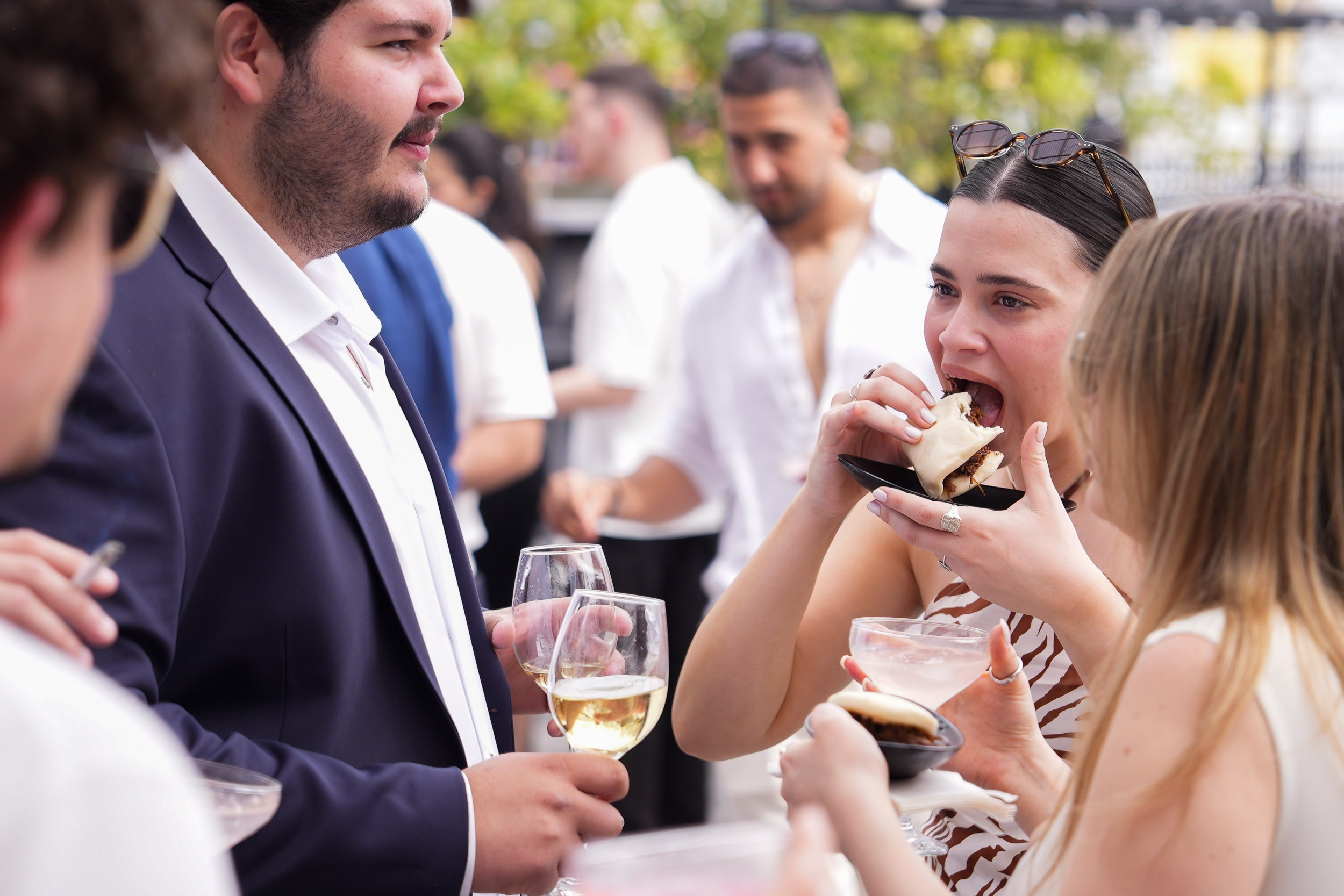 A wedding guest eats a bao bun during the cocktail reception