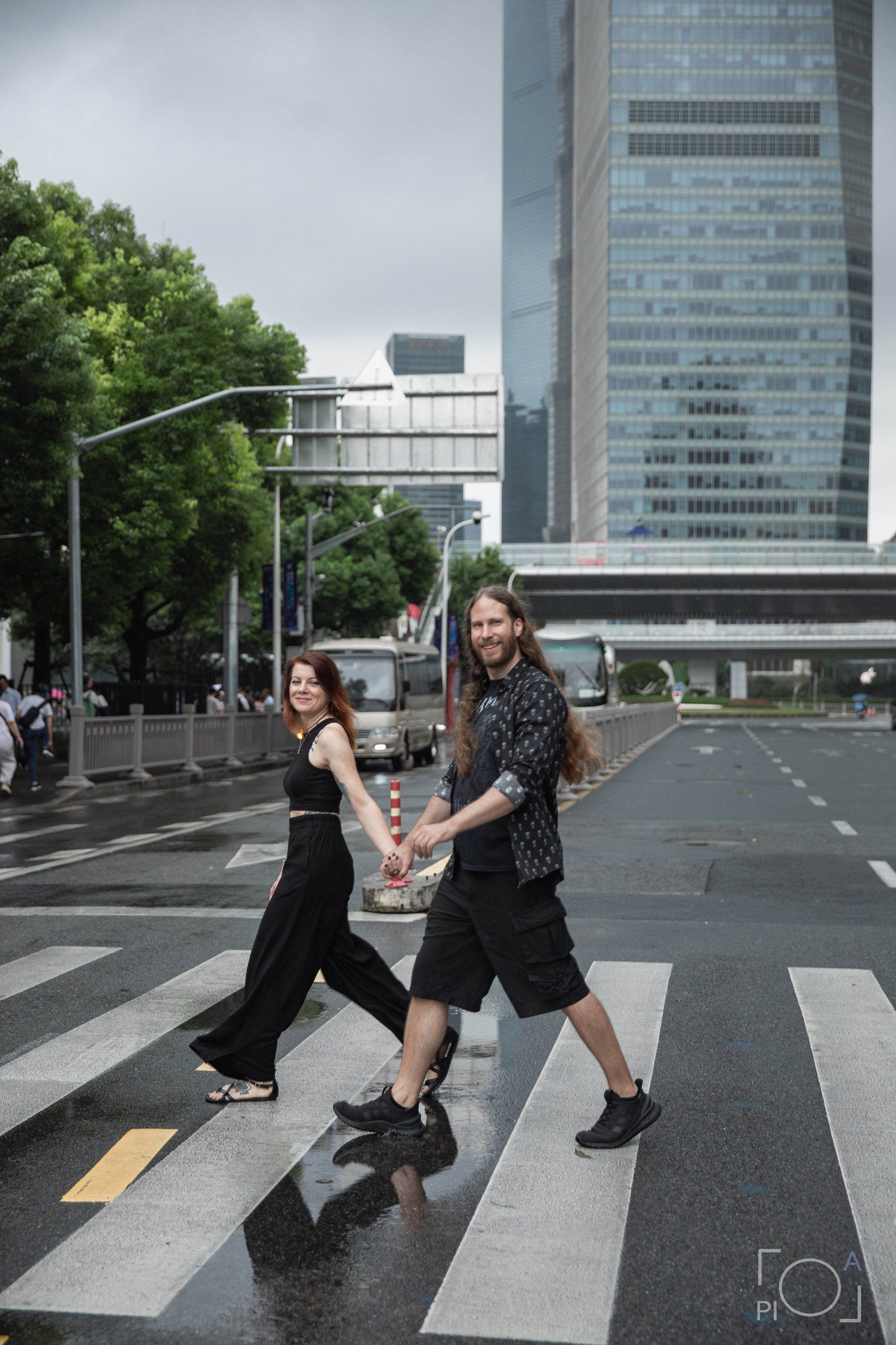 Пара шагает по пешеходному переходу в Шанхае