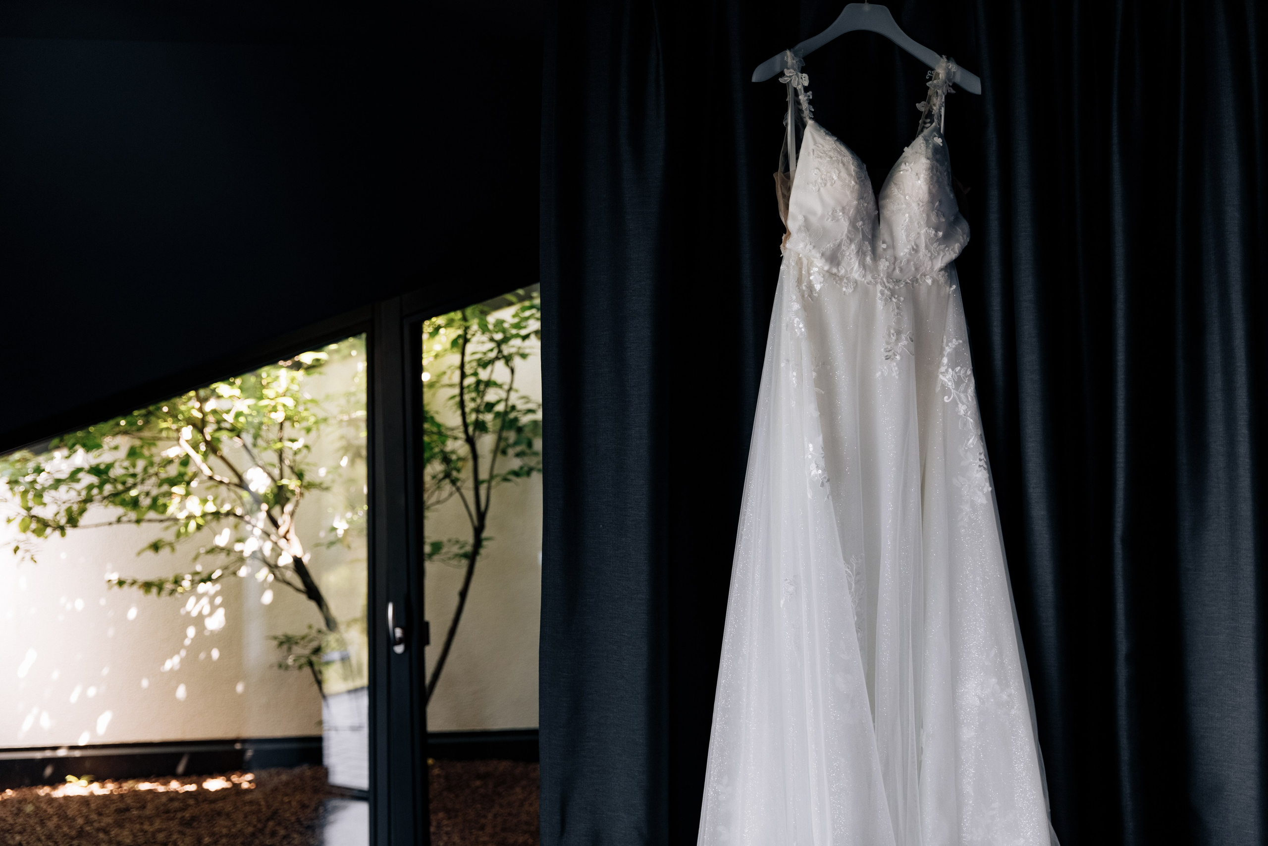 Hochzeitskleid hängt an der Wand in einem luxuriösen Hotelzimmer. Ein eleganter Moment der Hochzeitsvorbereitungen in einem exklusiven Ambiente.