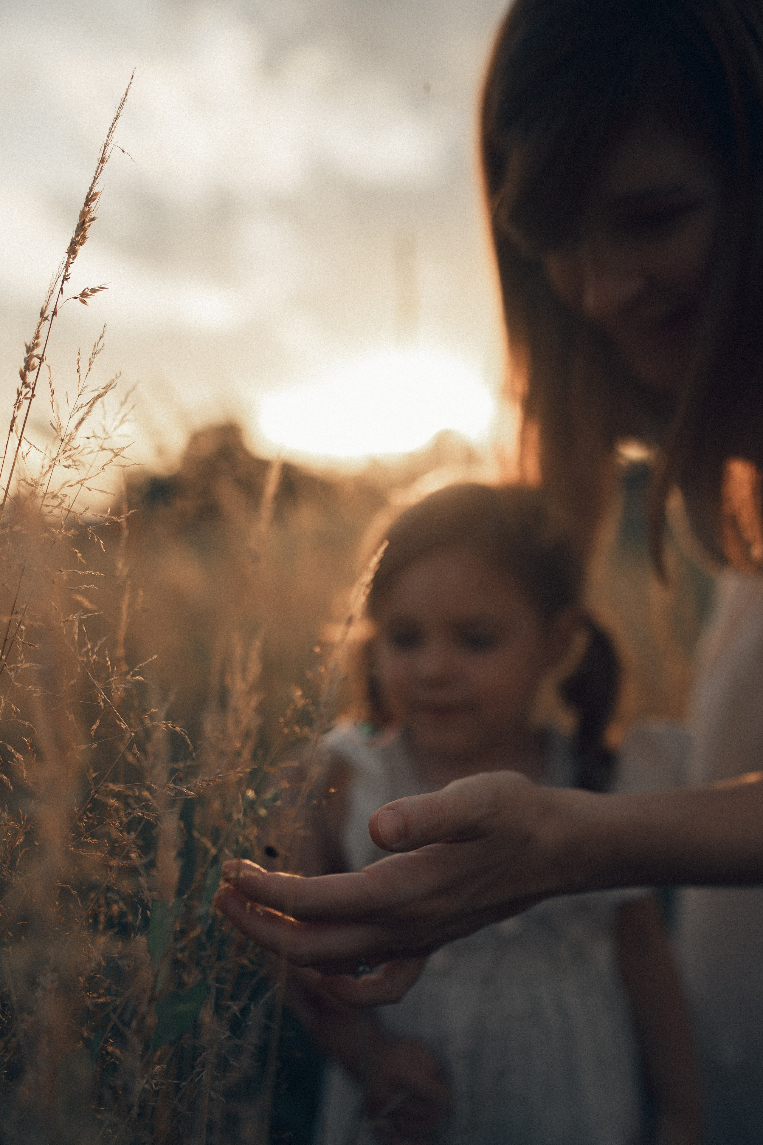 Shooting gravidanza al tramonto – mamma incinta vestita di bianco tra natura e luce calda