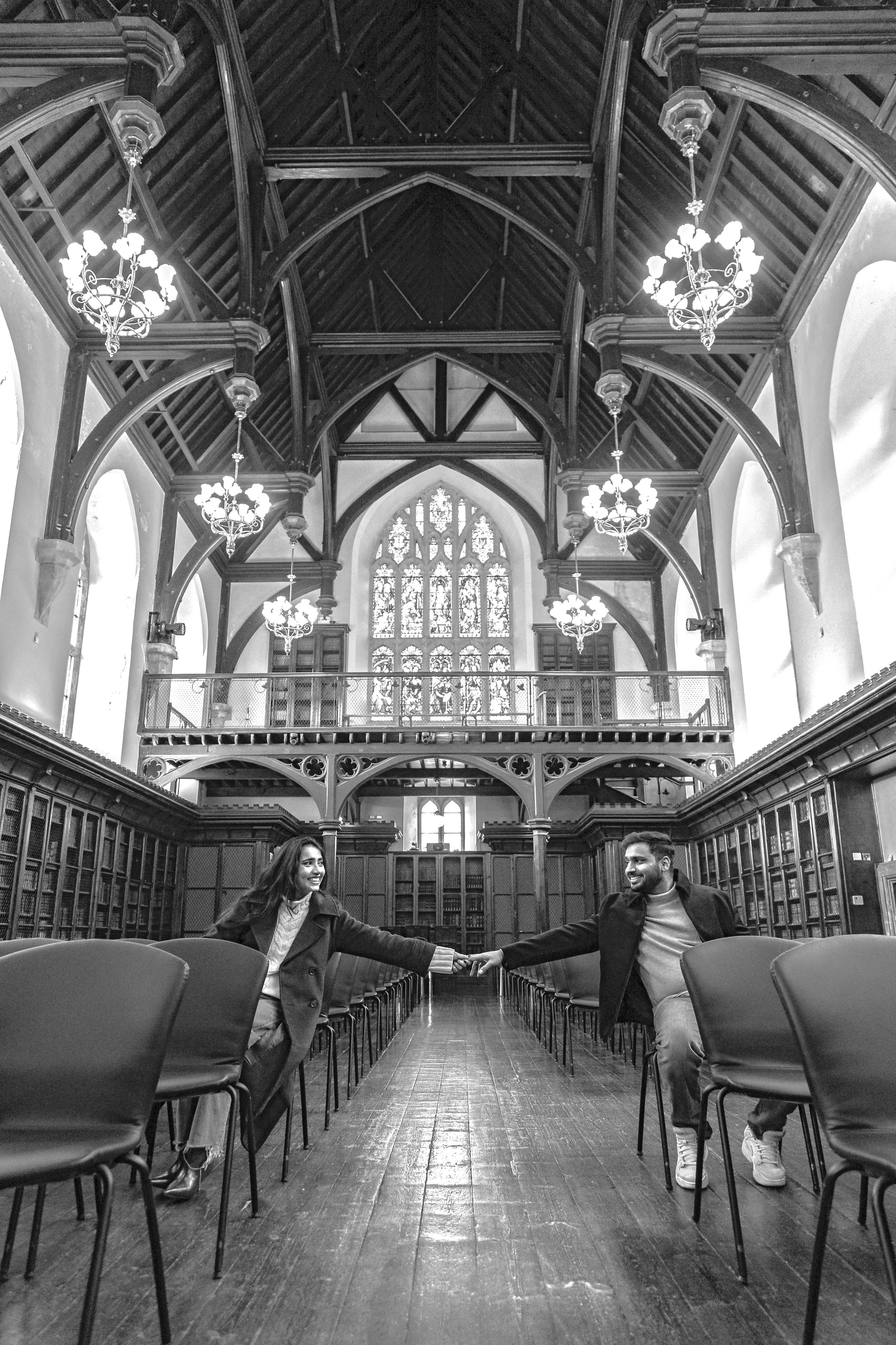 A striking black and white composition capturing distance and connection within a grand architectural space.