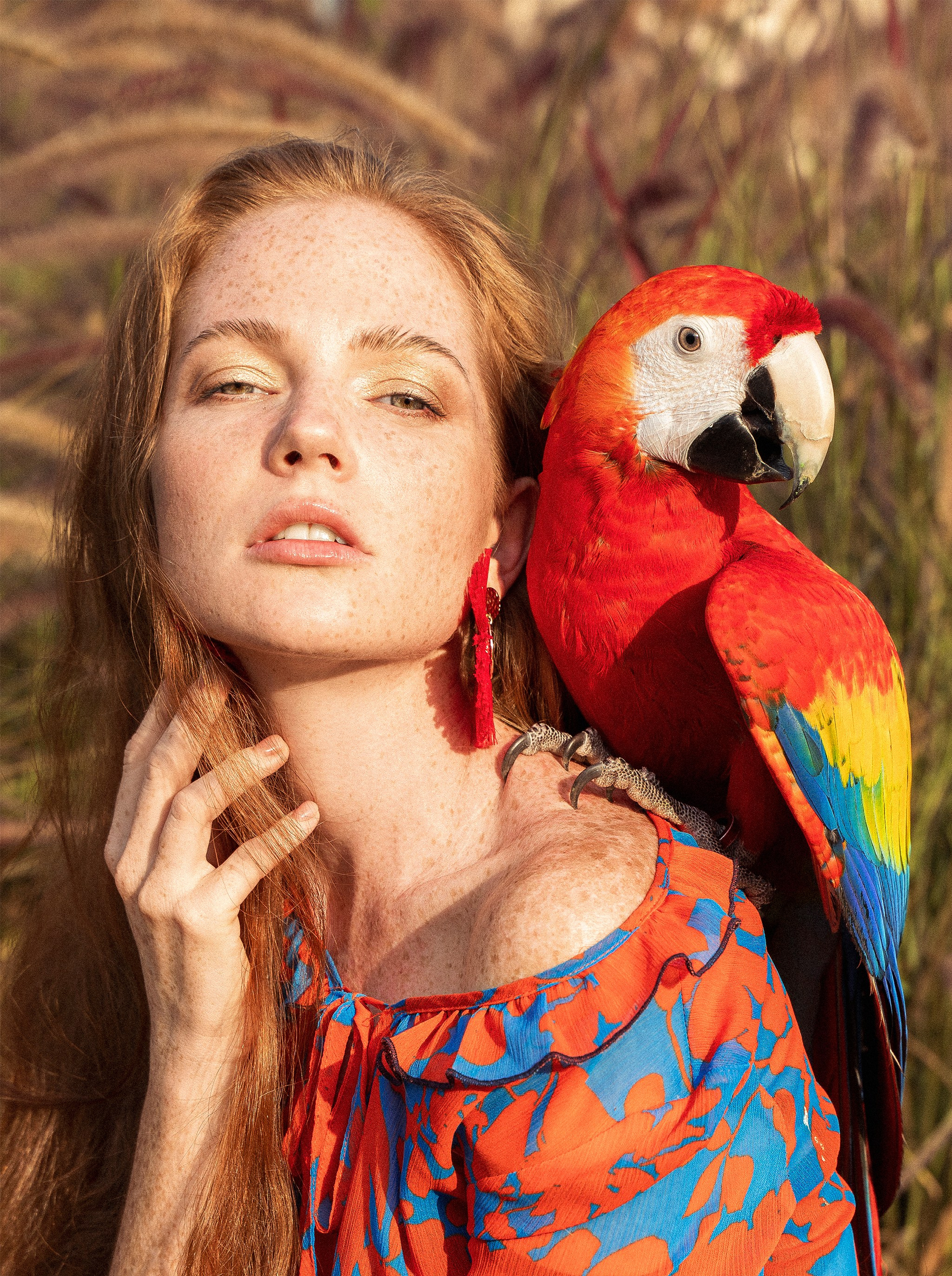 A vibrant photo of a woman with a colorful parrot perched on her hand. The parrot’s bright feathers and the model’s joyful expression reflect the lively and playful bond between them. The tropical background enhances the exotic feel of the image, celebrating the dynamic relationship between humans and their avian friends.