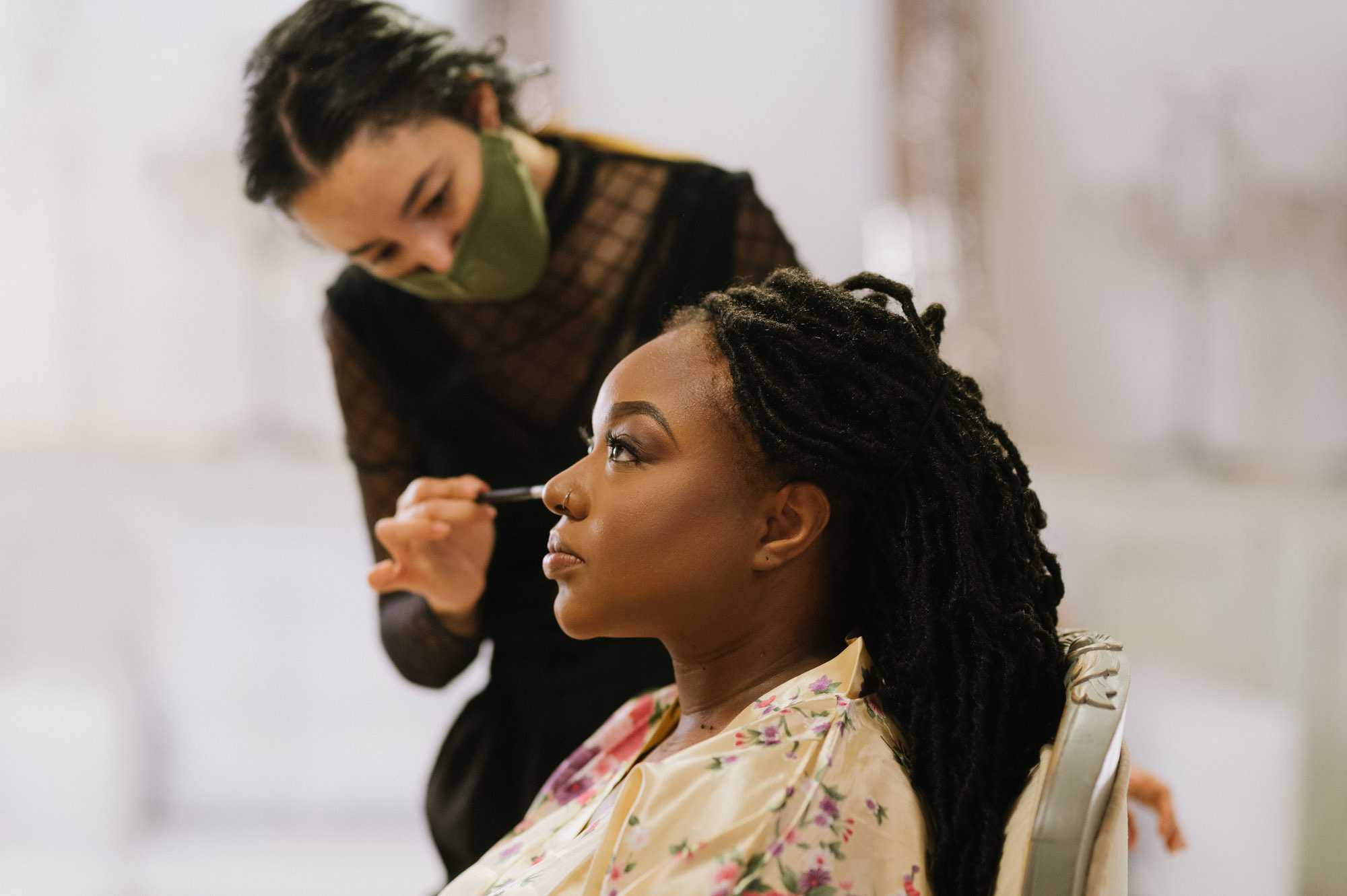 The bride's makeup is applied and she is turned in profile. 