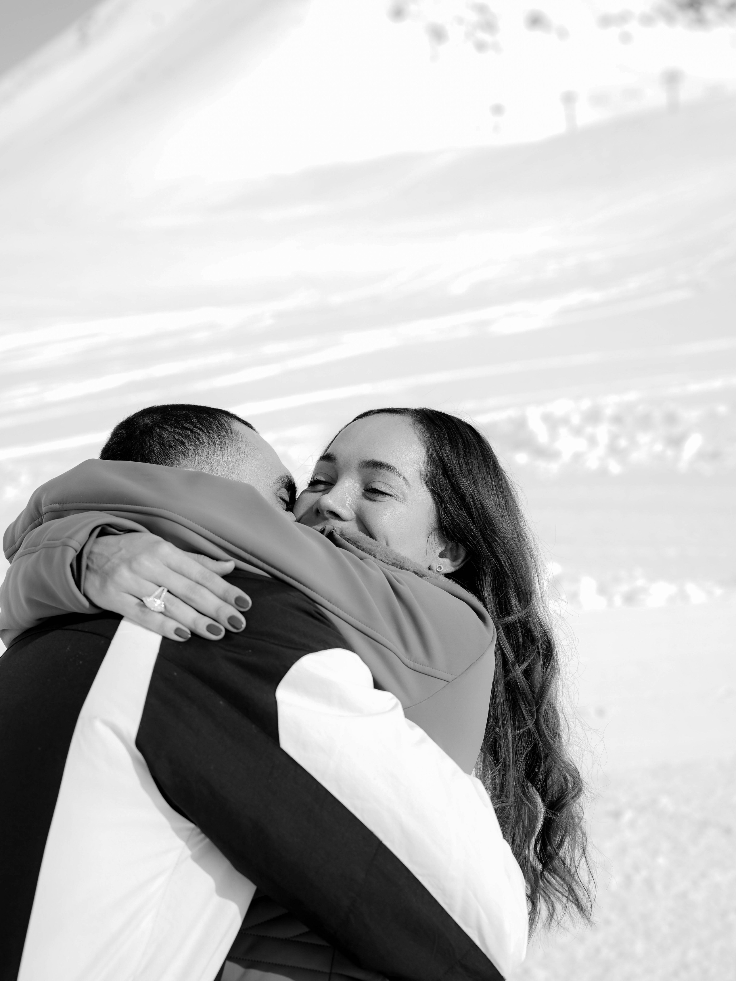 Couple hugging on snow in mountain setting