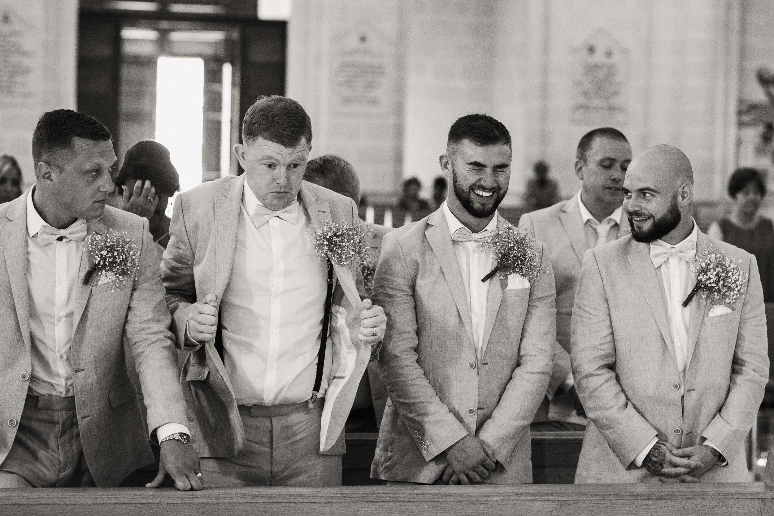 Friends of the groom are laughing in the cathedral