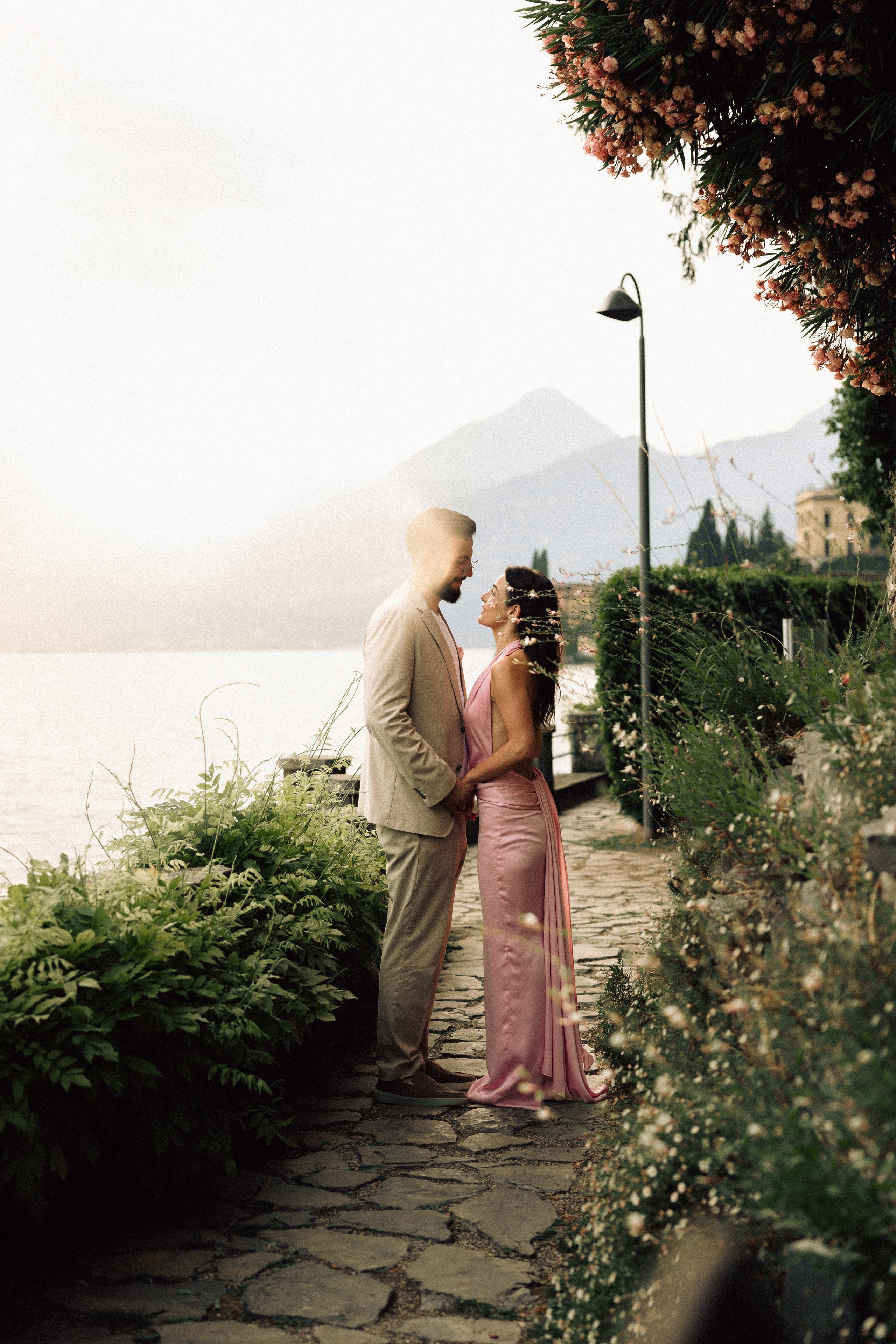 Newly engaged couple looking at each other with Lake Como in the background at sunset