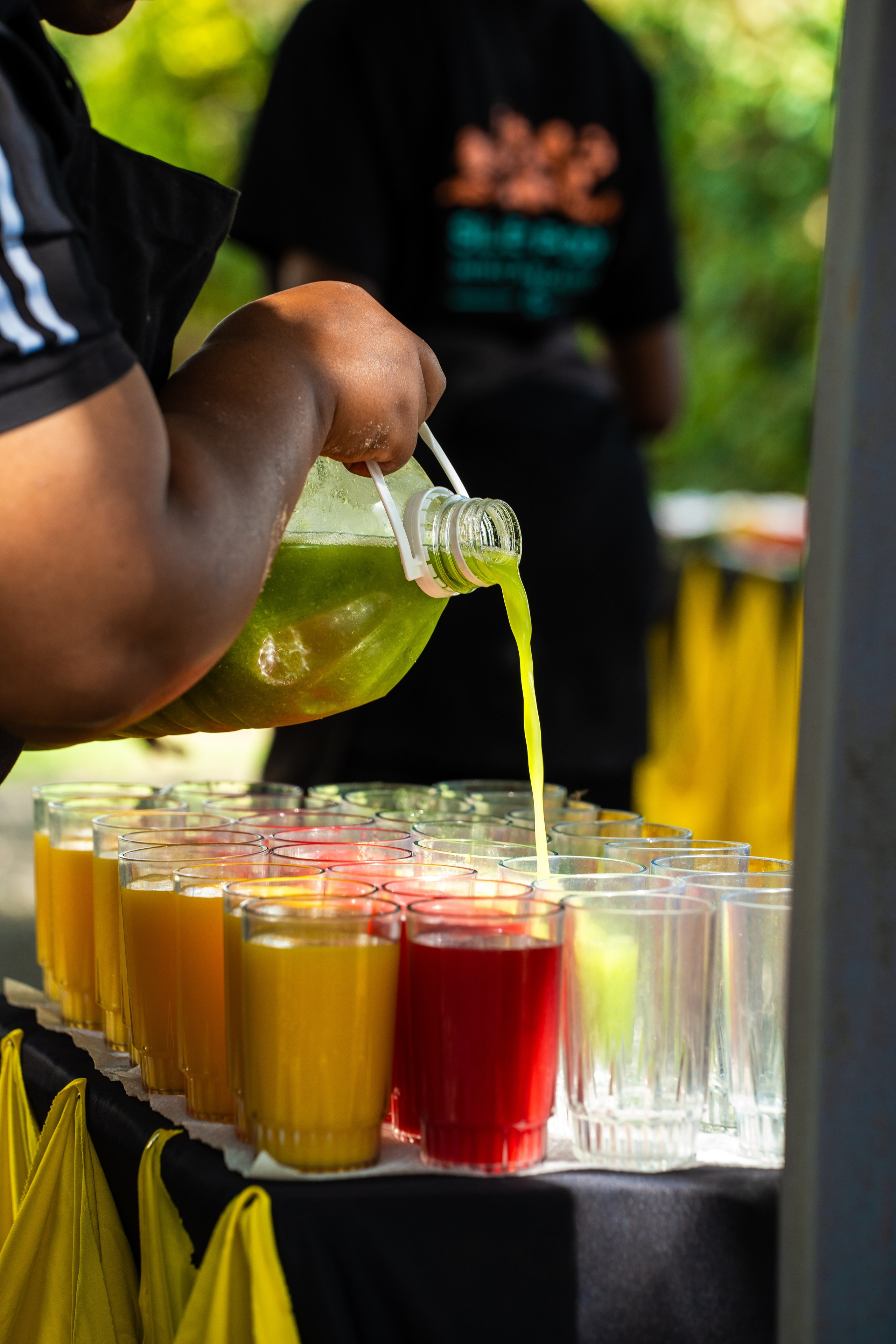 An insert shot of fresh juice being poured on a table full of glass cups