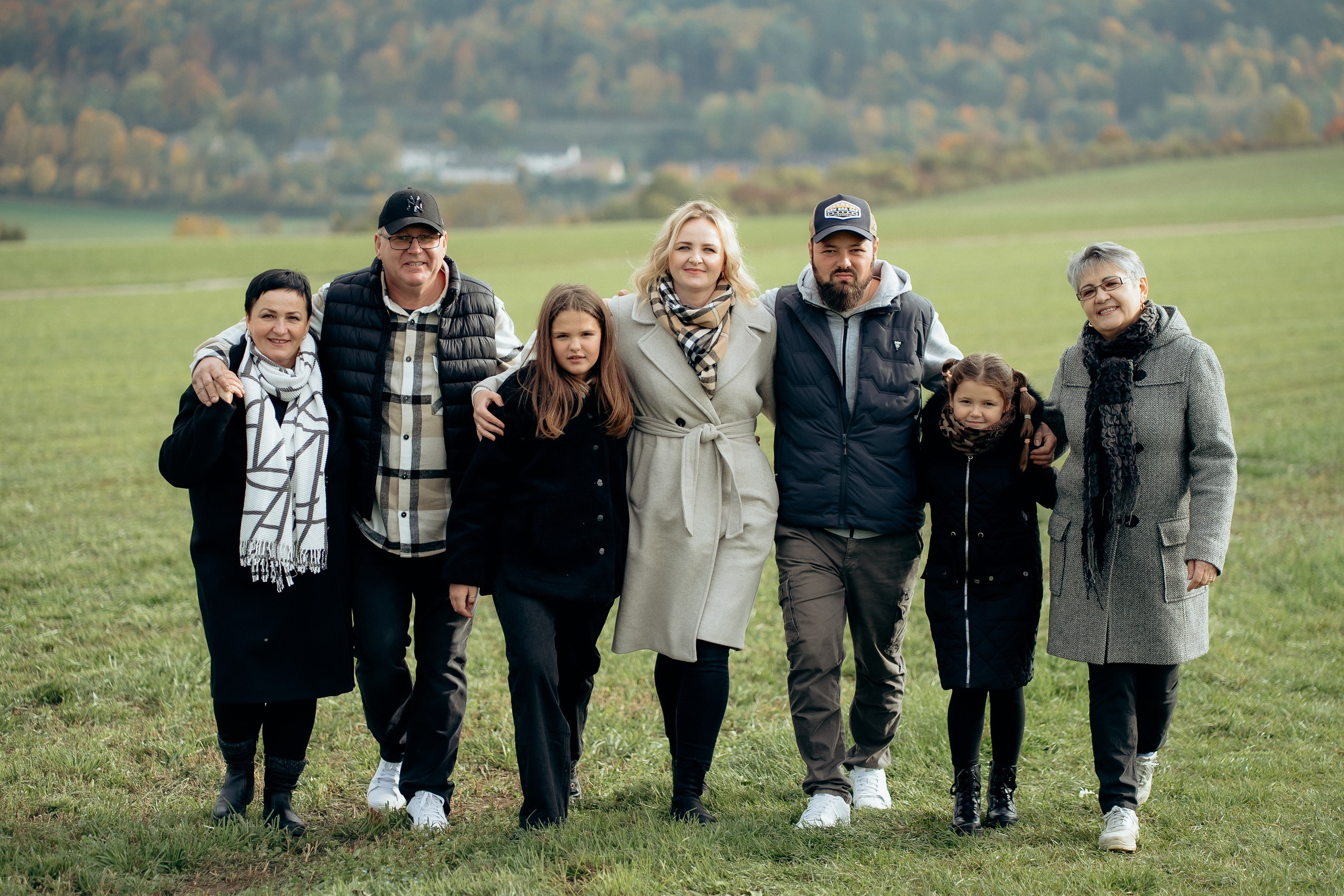 Gruppenportrait einer großen Familie bei einem Mehrgenerationen-Fotoshooting im Grünen.