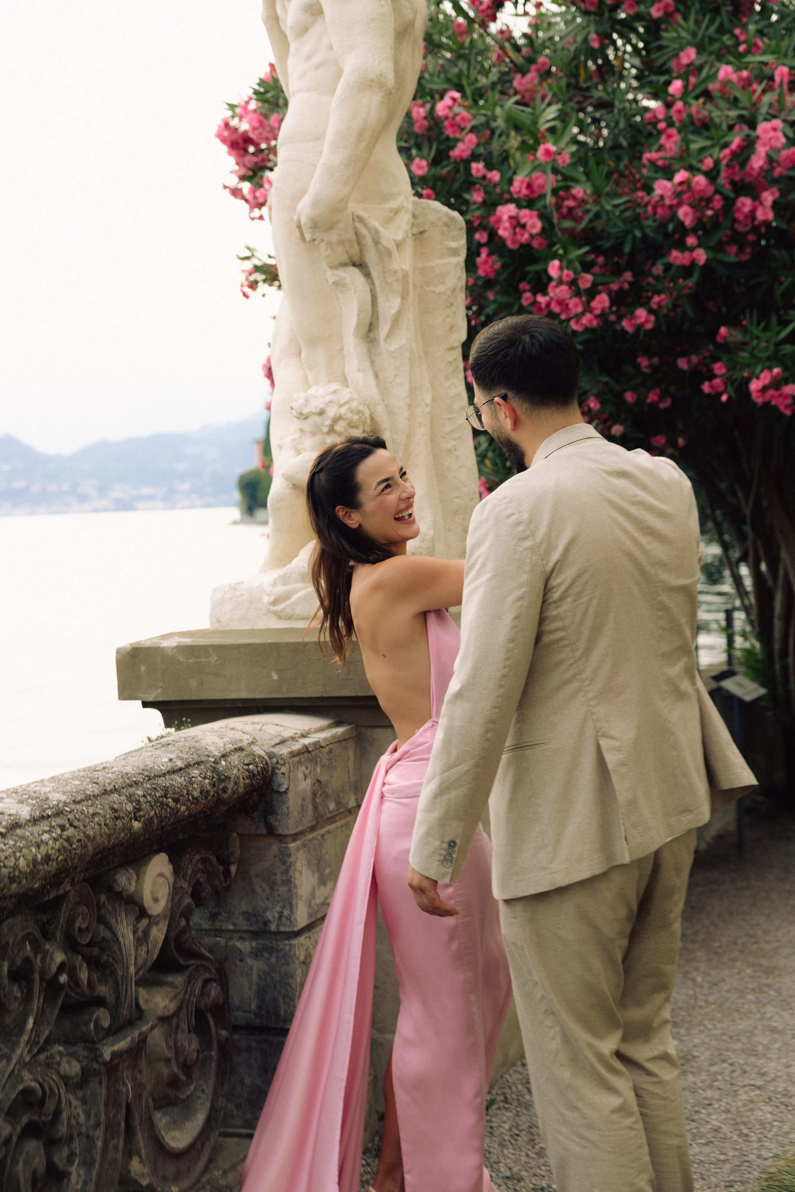 Newly engaged couple walking together along the shores of Lake Como