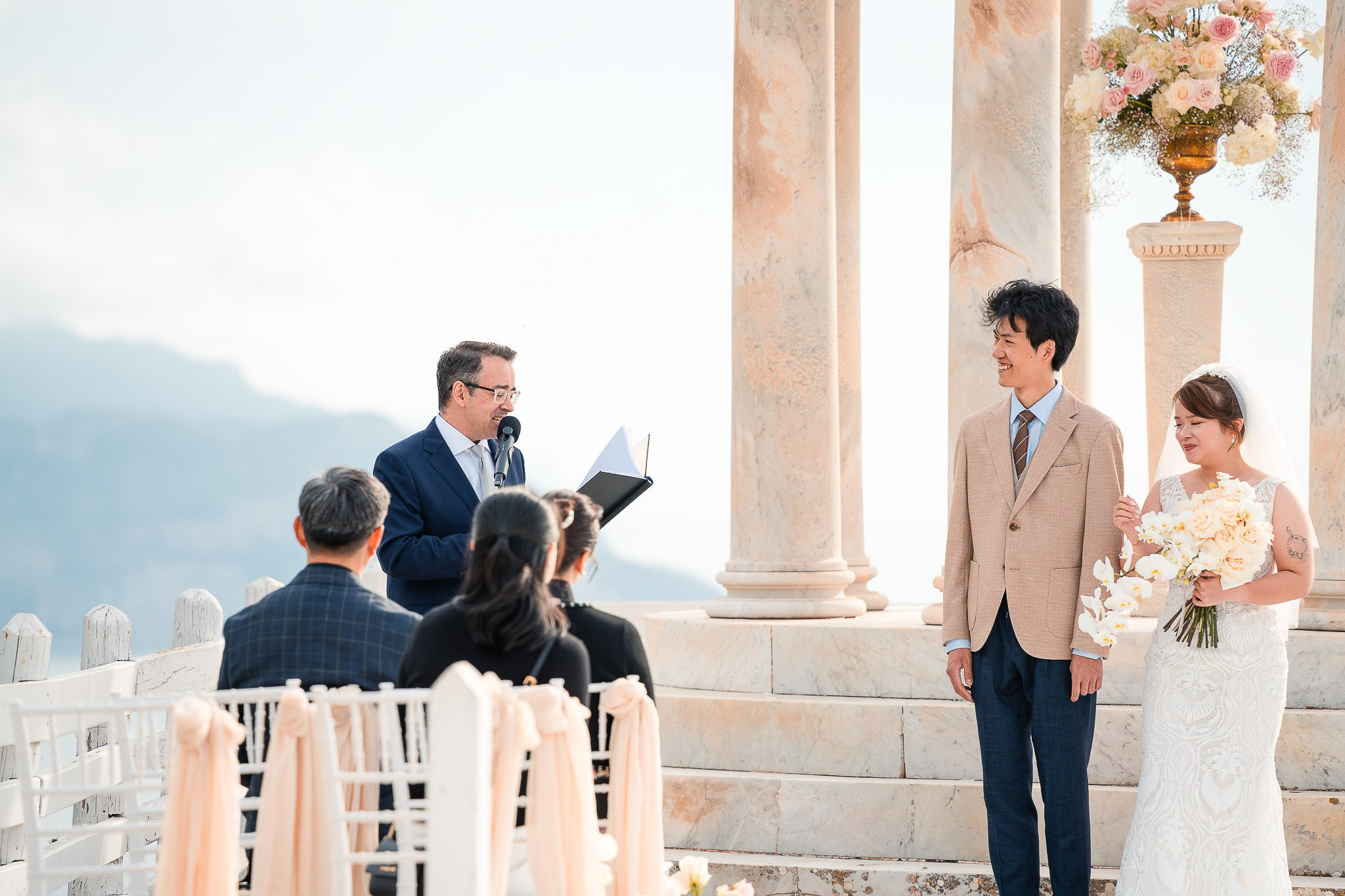 Wedding officiant conducting the ceremony for bride and groom overlooking the sea at Son Marroig