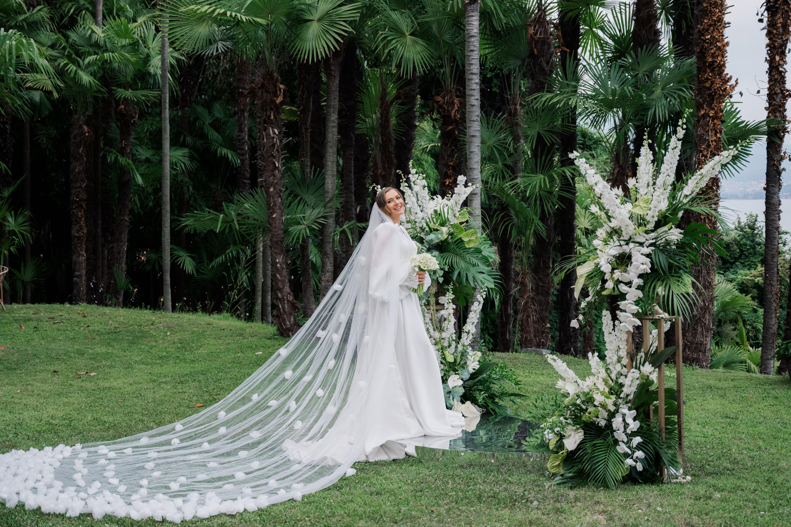 a bride standing in front of a wedding arch