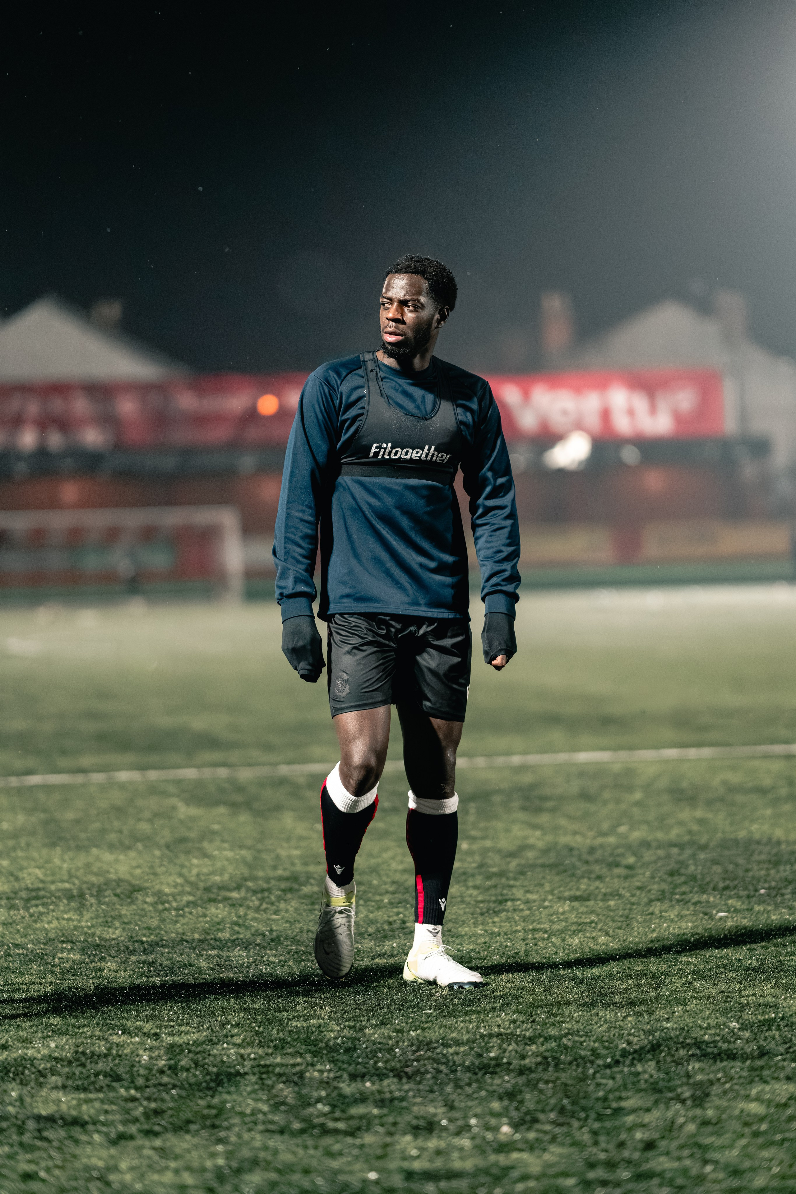 Kennedy Digie walking on the pitch during warm-up under floodlights before Tamworth vs Alvechurch