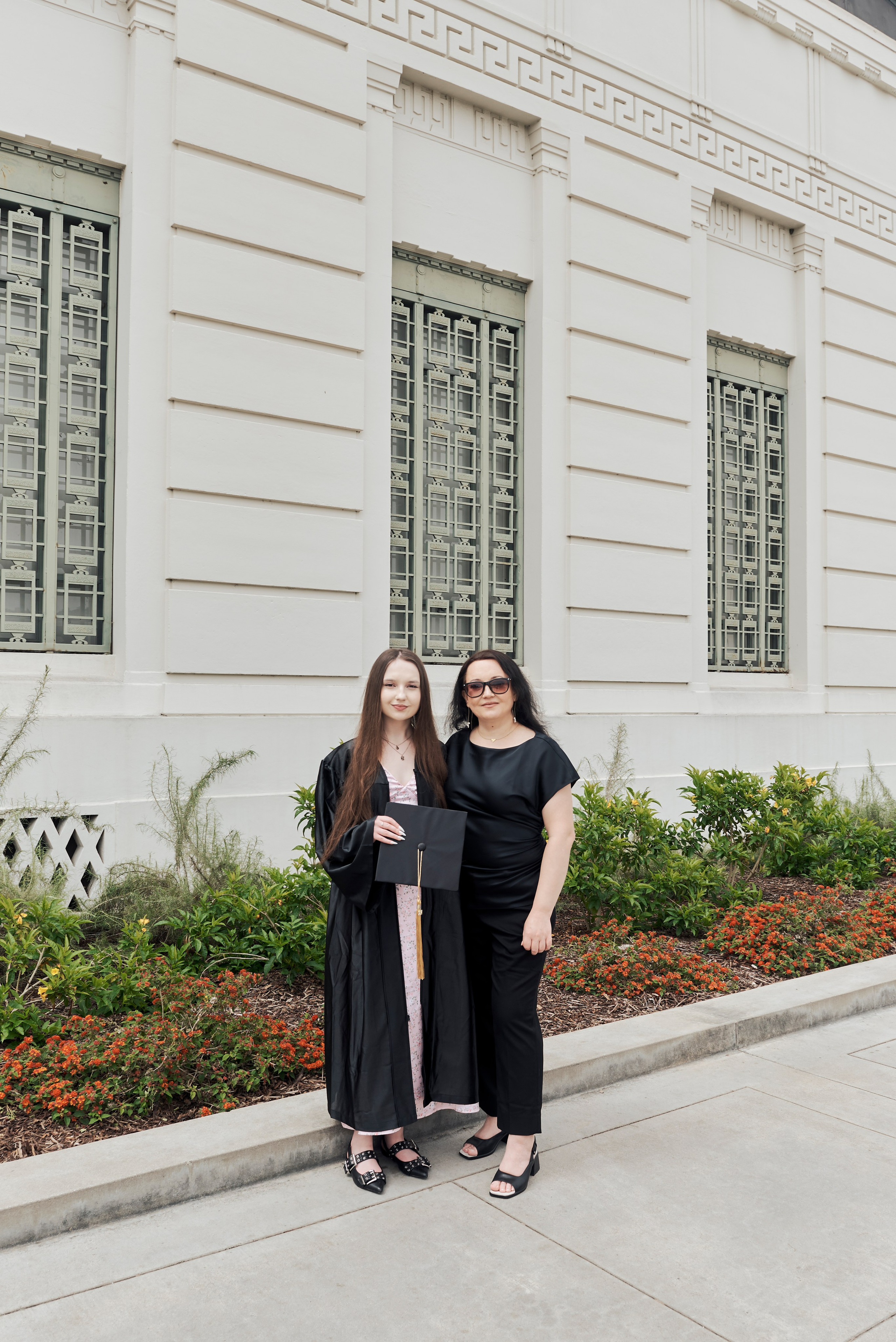 Close-up graduation photo of a student’s cap and diploma with the LA skyline in the background