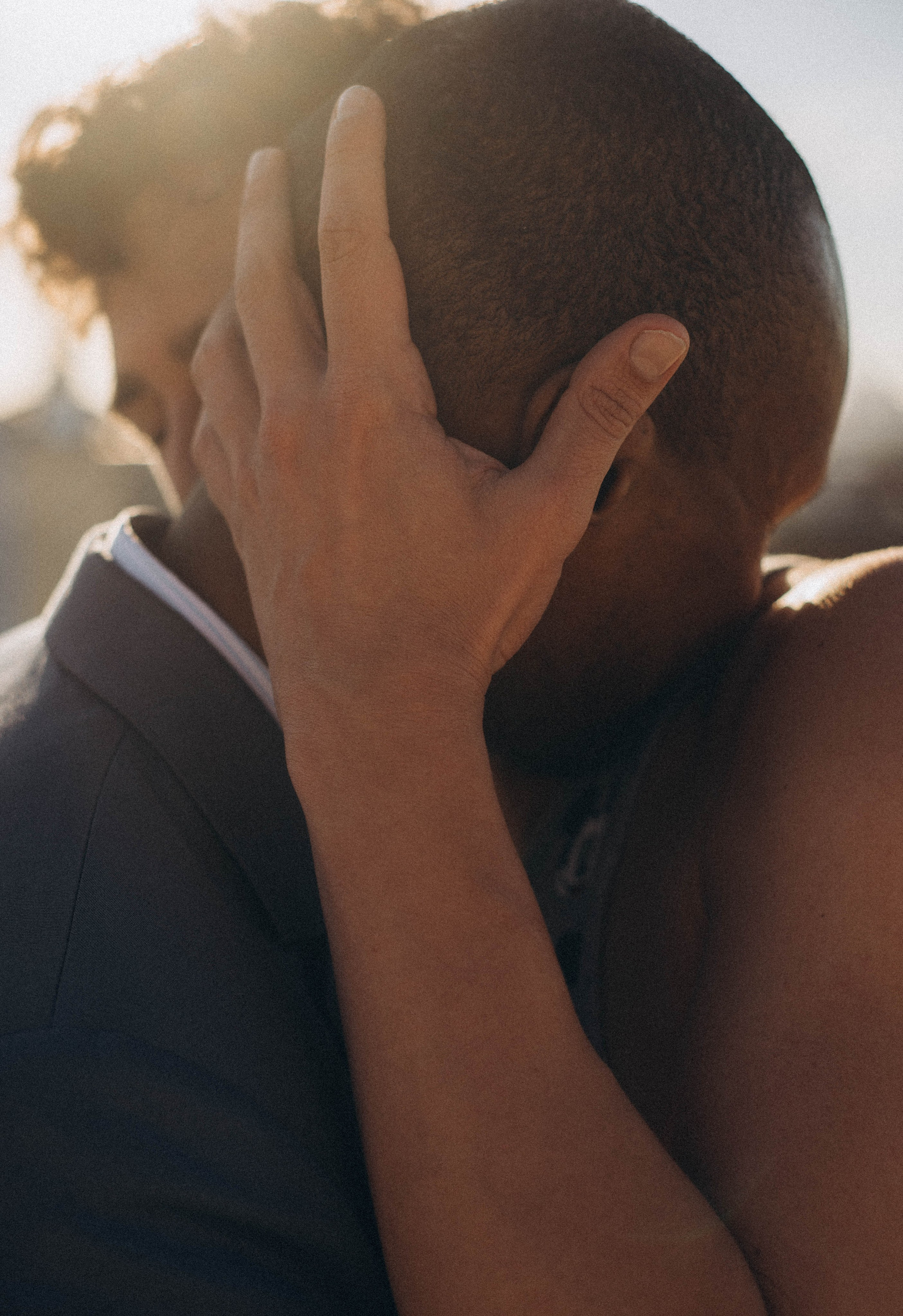 Couple hugging after proposal on Brooklyn Bridge bench.