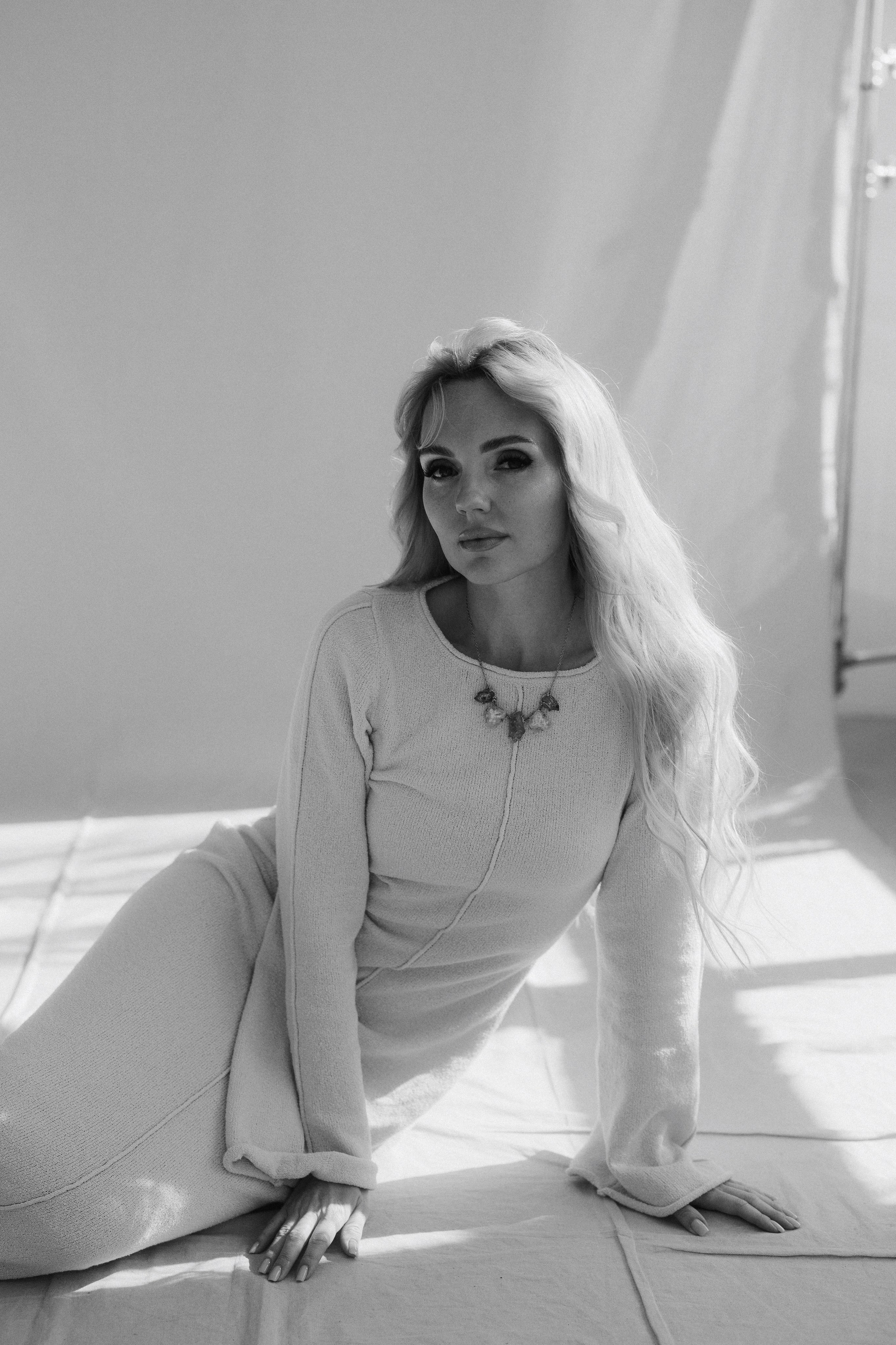 Black and white portrait of a seated woman in soft natural light with minimalist fine art styling. Чёрно-белый портрет сидящей девушки в мягком естественном свете с художественной минималистичной эстетикой.