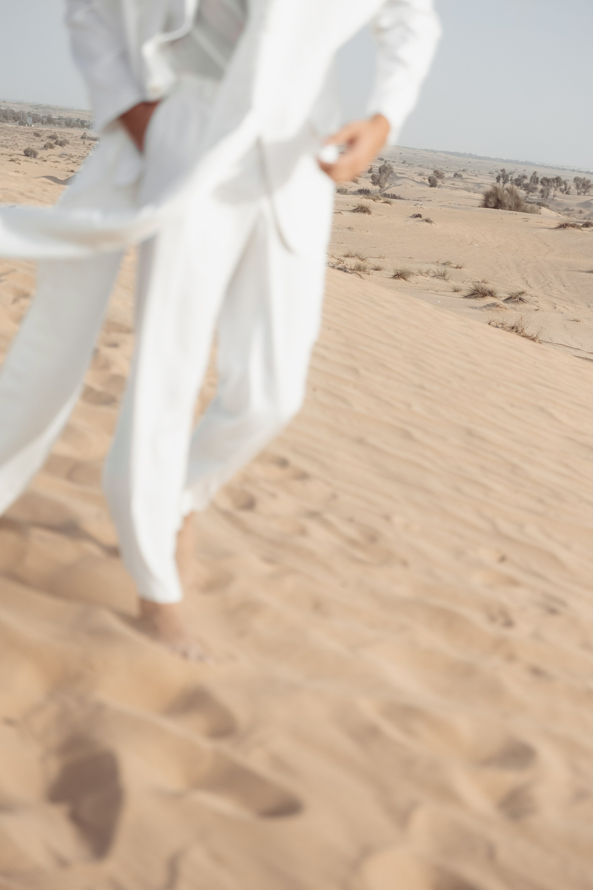 Groom is playing with the sand in a Dubai desert