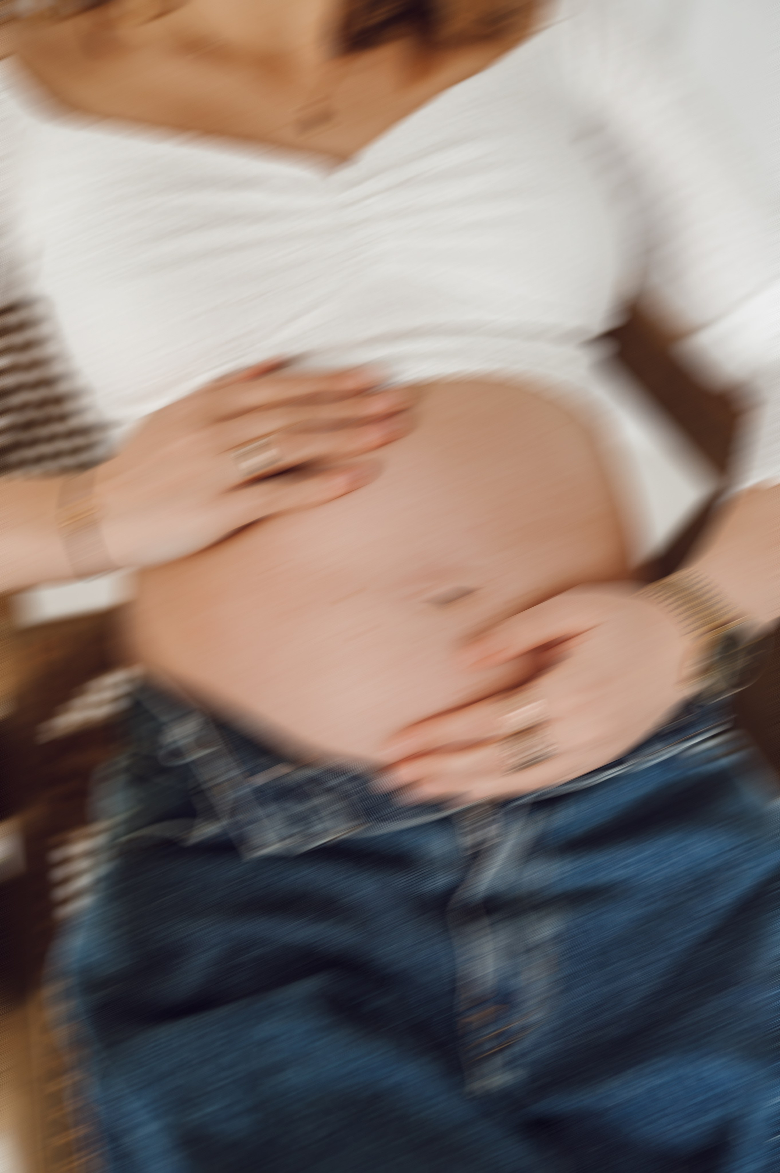 Brzuch ciążowy w objęciach partnera – naturalna sesja ciążowa, fotografia rodzinna Poznań.