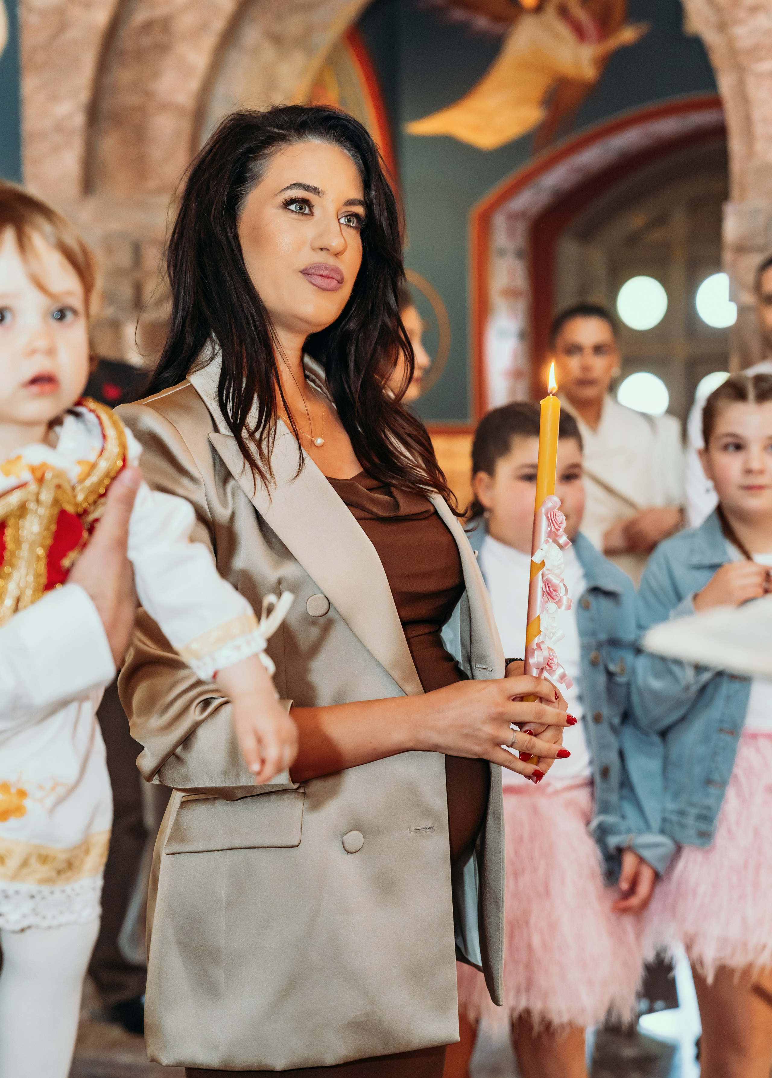 Kuma drzi svecu na krstenju