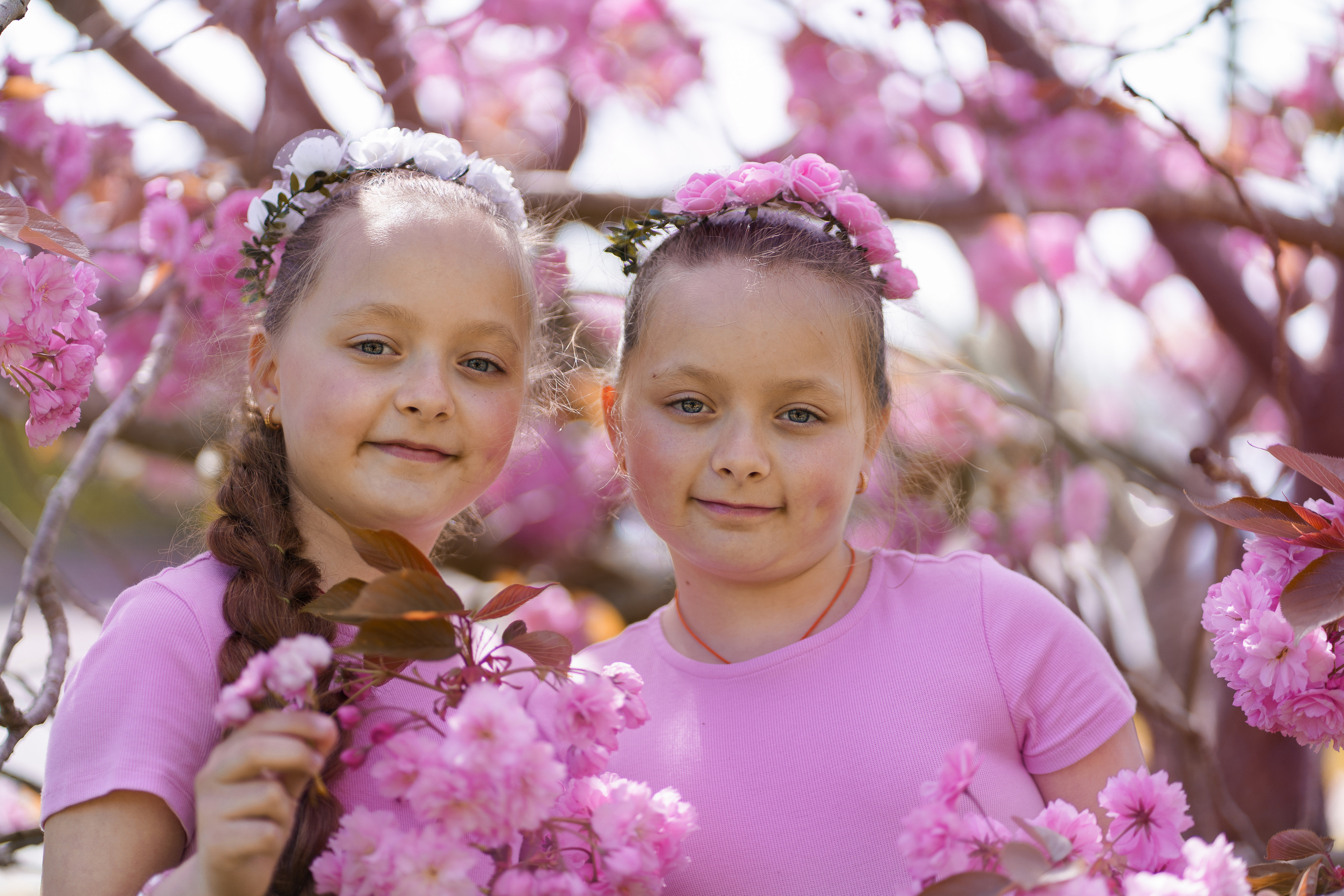 Little sisters in pink blossom. Jelena Upleja children and family photographer in Bognor Regis