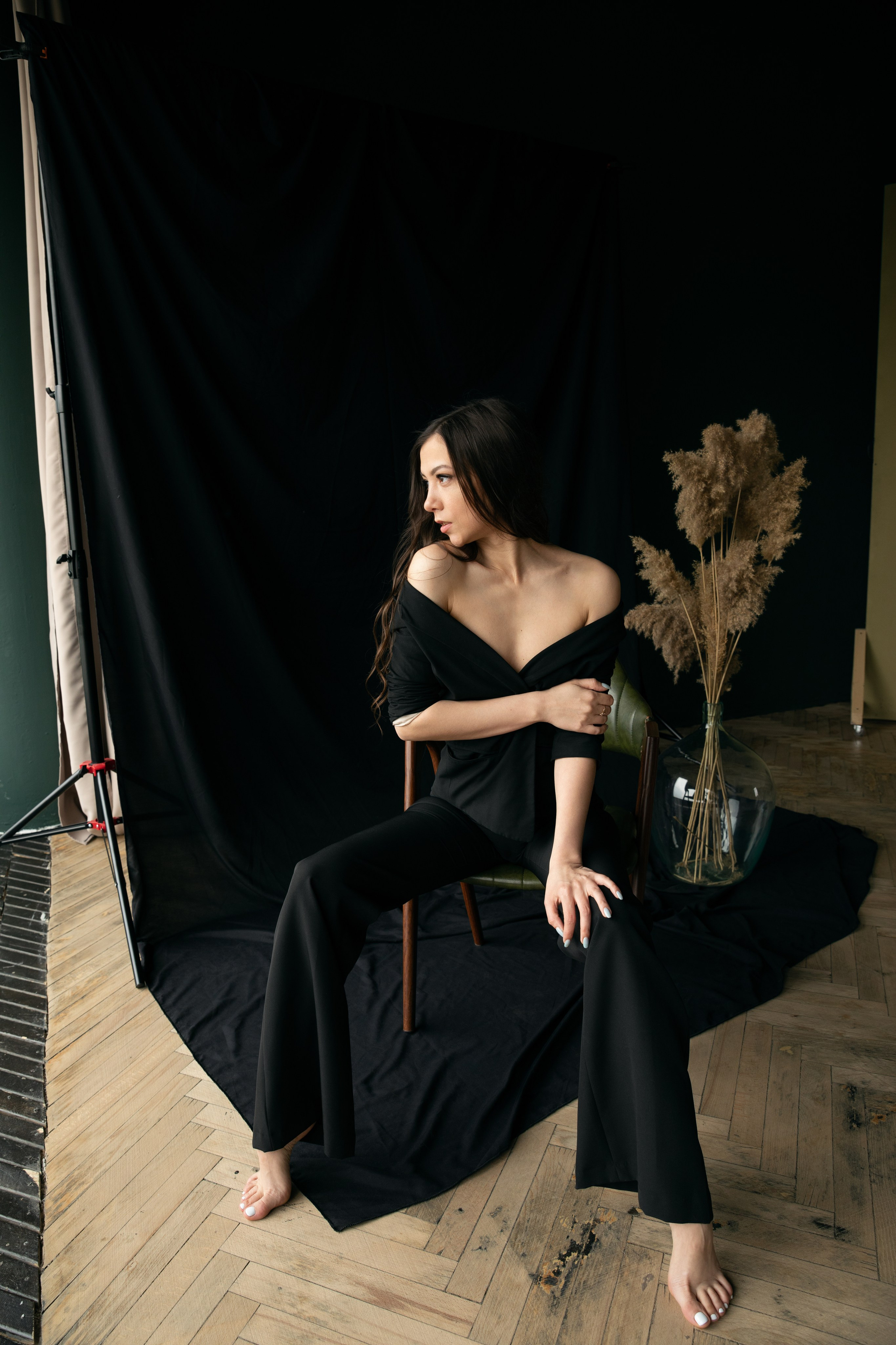 Frau sitzt seitlich im schulterfreien schwarzen Anzug