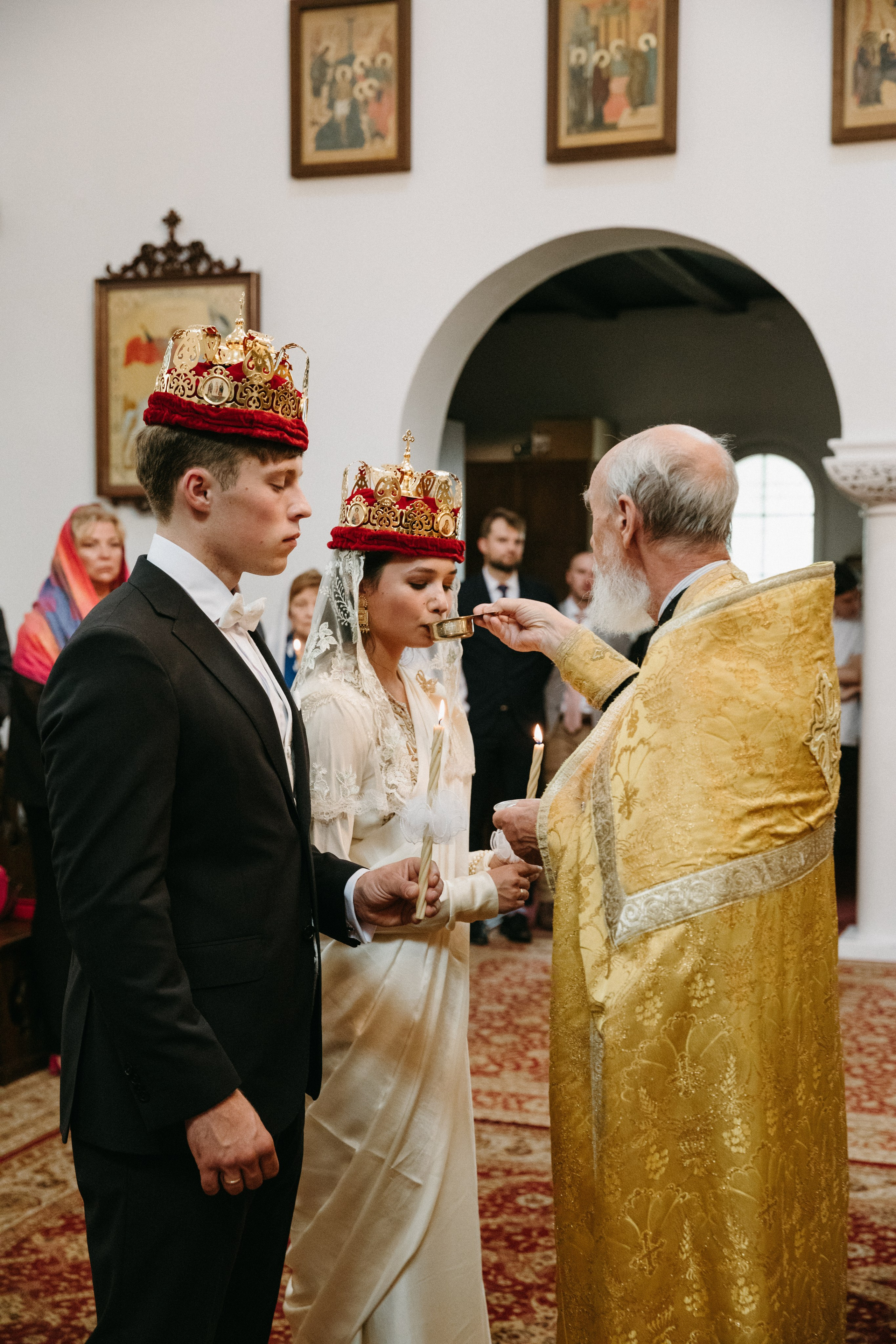 Orthodoxer Priester reicht der Braut Wein als Teil des Hochzeitsrituals