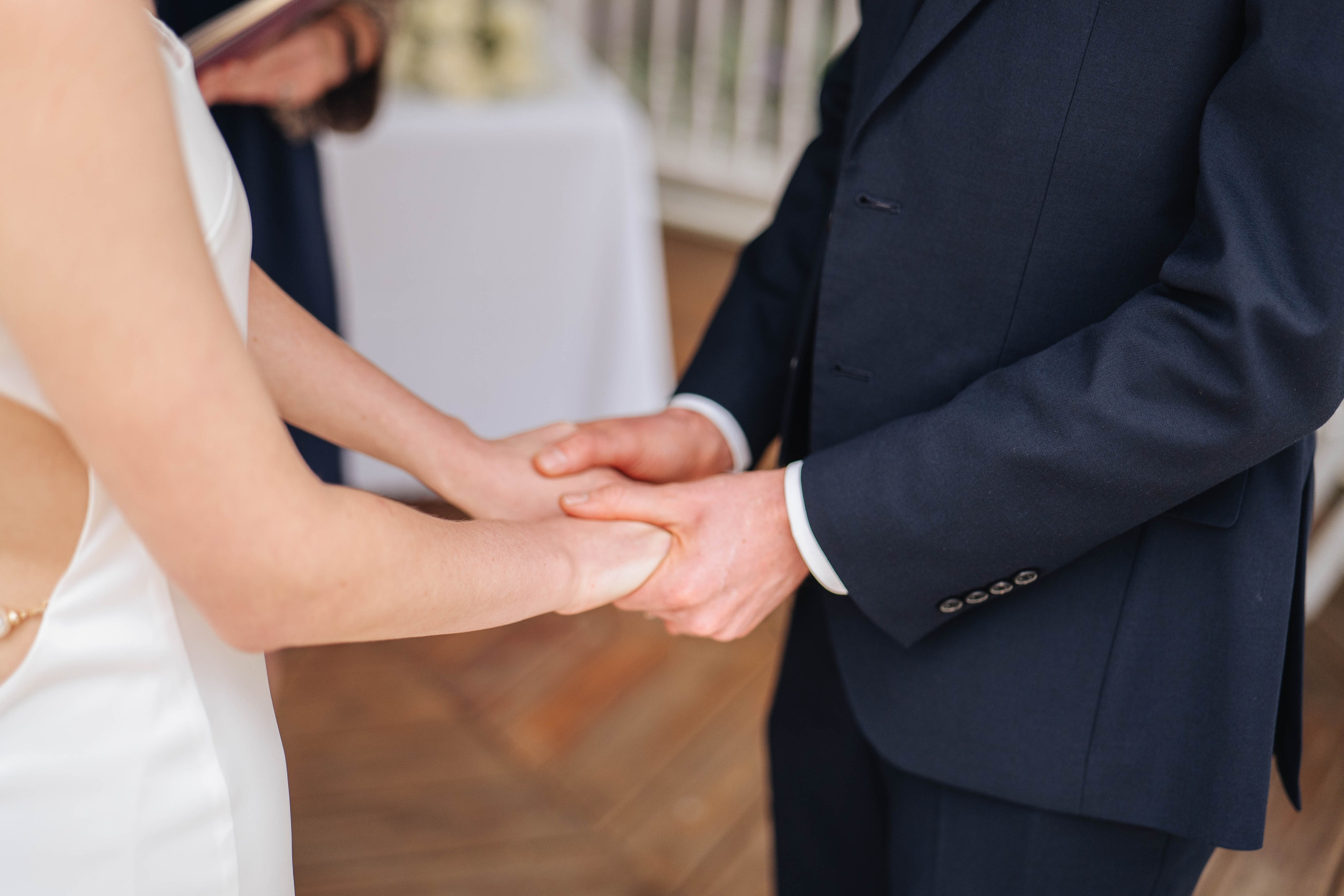 bride and groom at the ceremony, holding hands