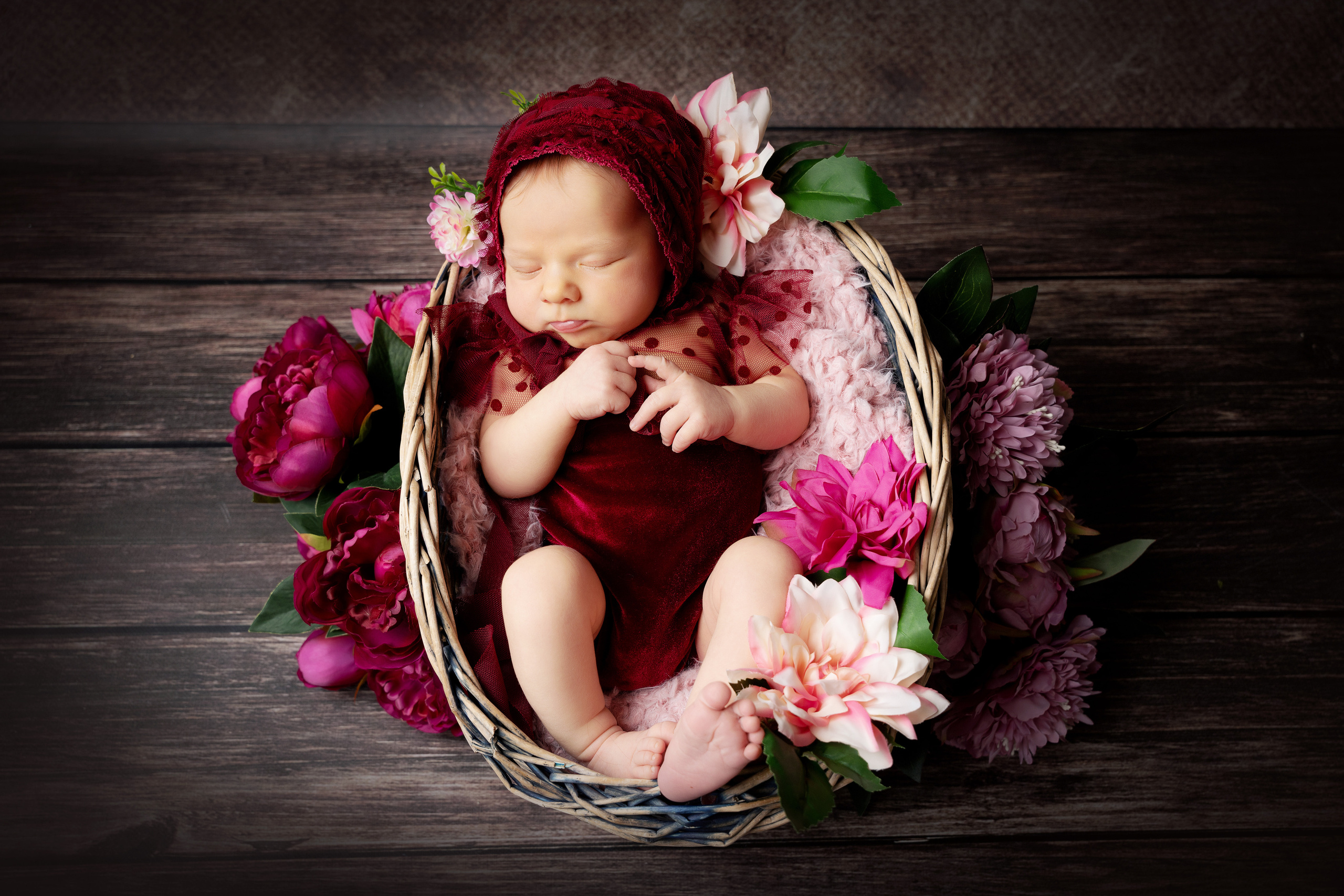 Das Baby ist eingekuschelt in ein zartes Tuch und schläft tief und fest