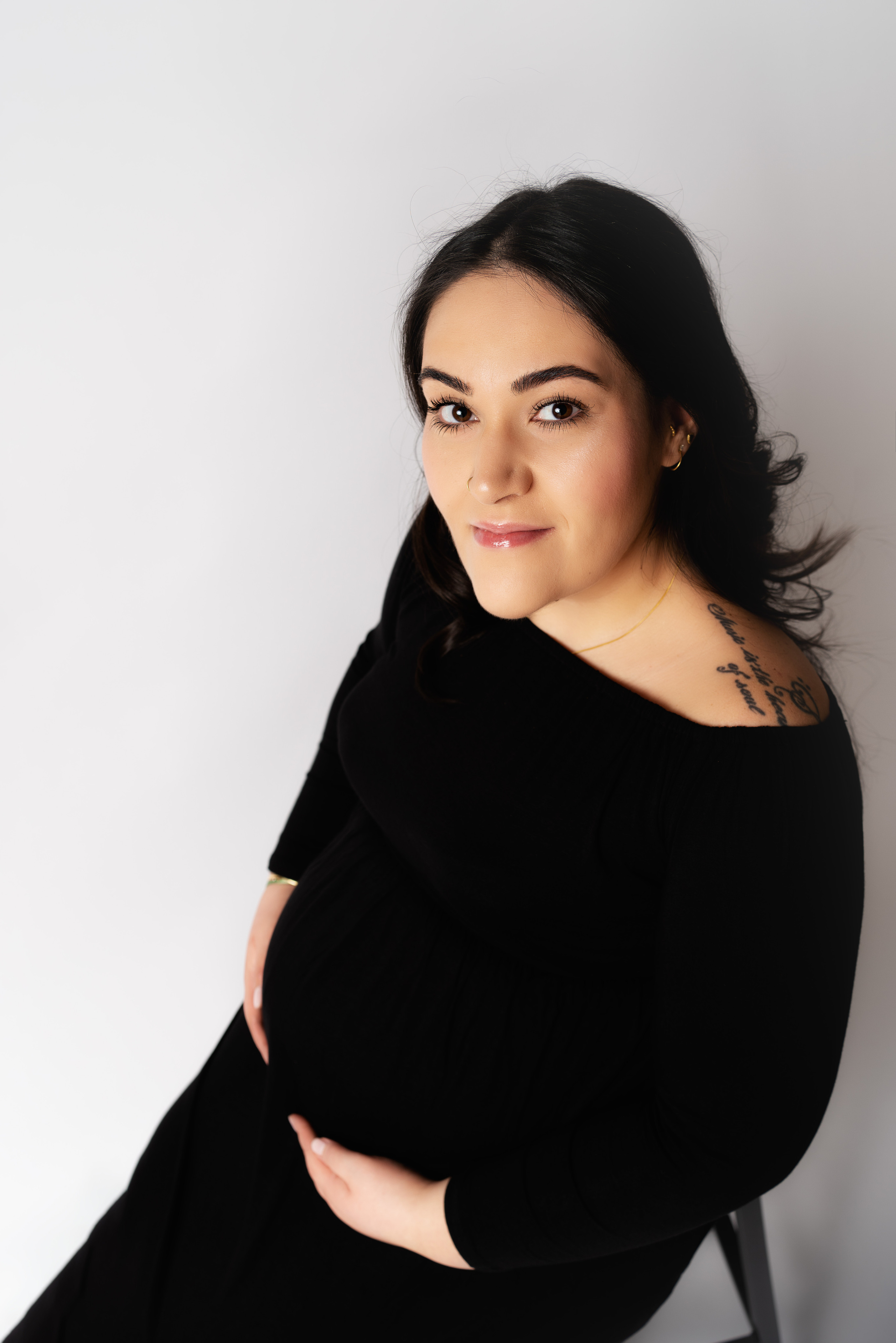 Eine schwangere Frau sitzt friedlich auf einer Couch