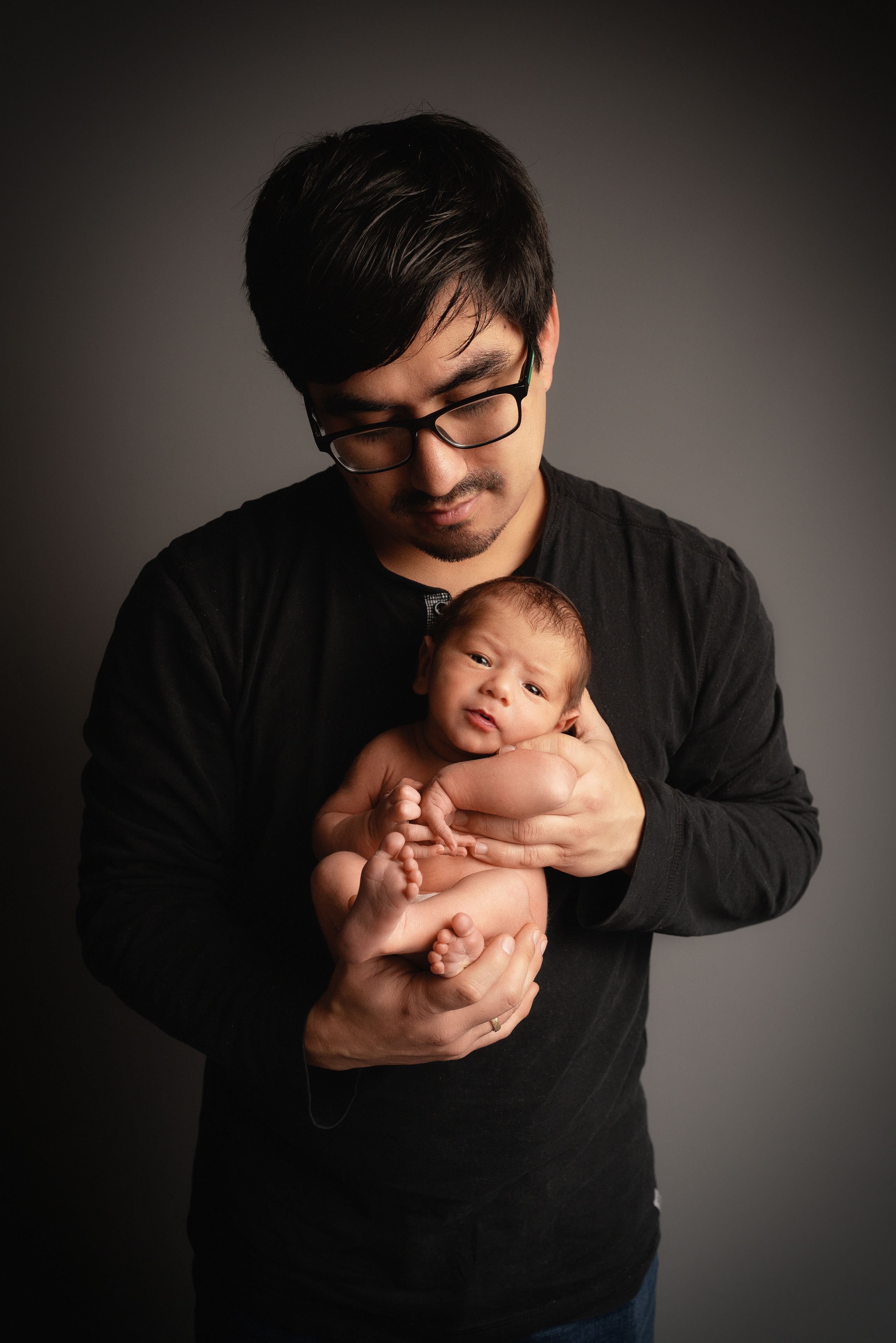 Ein junger Mann, der stolz seinen neuen Sohn hält