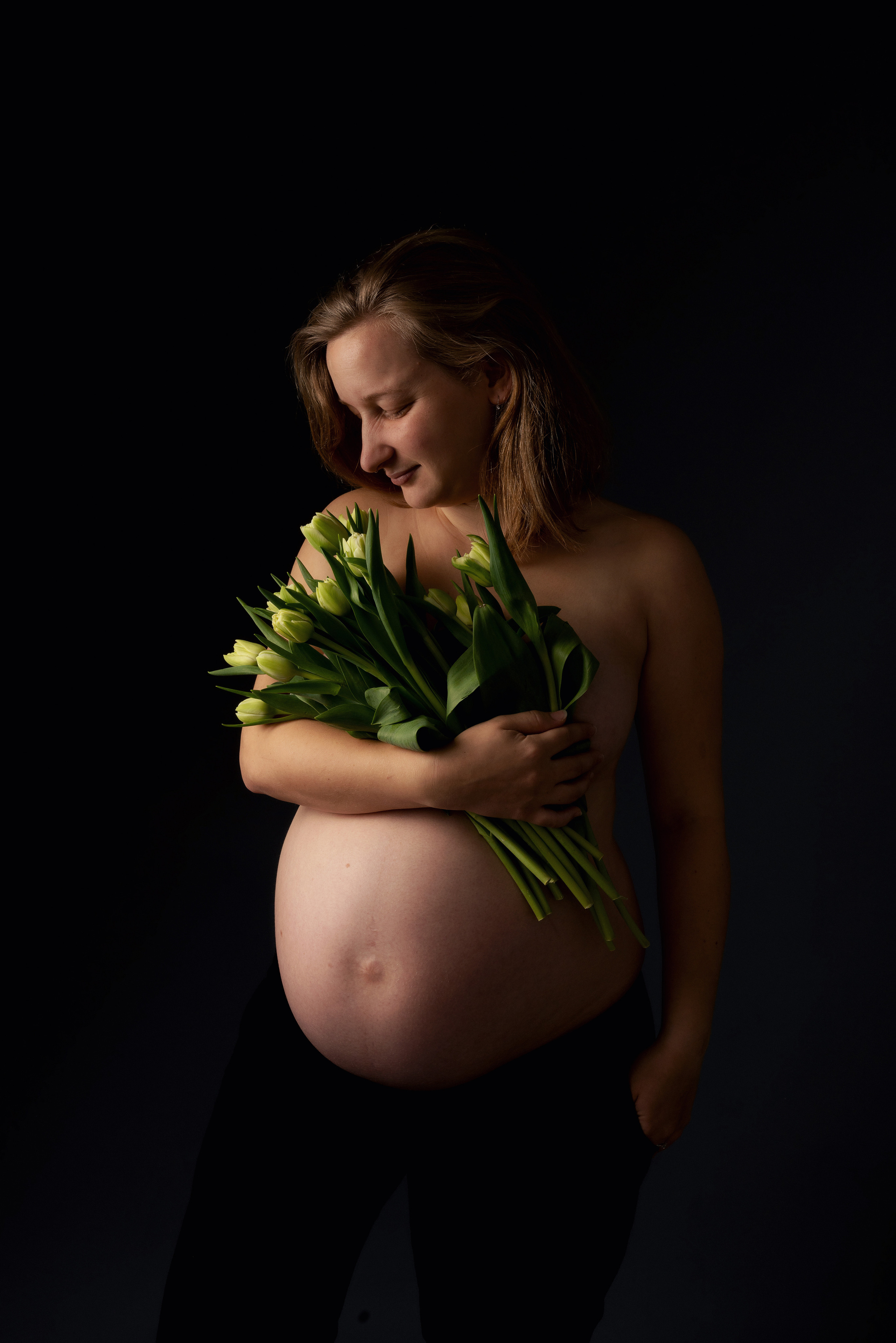 Eine schwangere Frau geht durch eine Blumenwiese