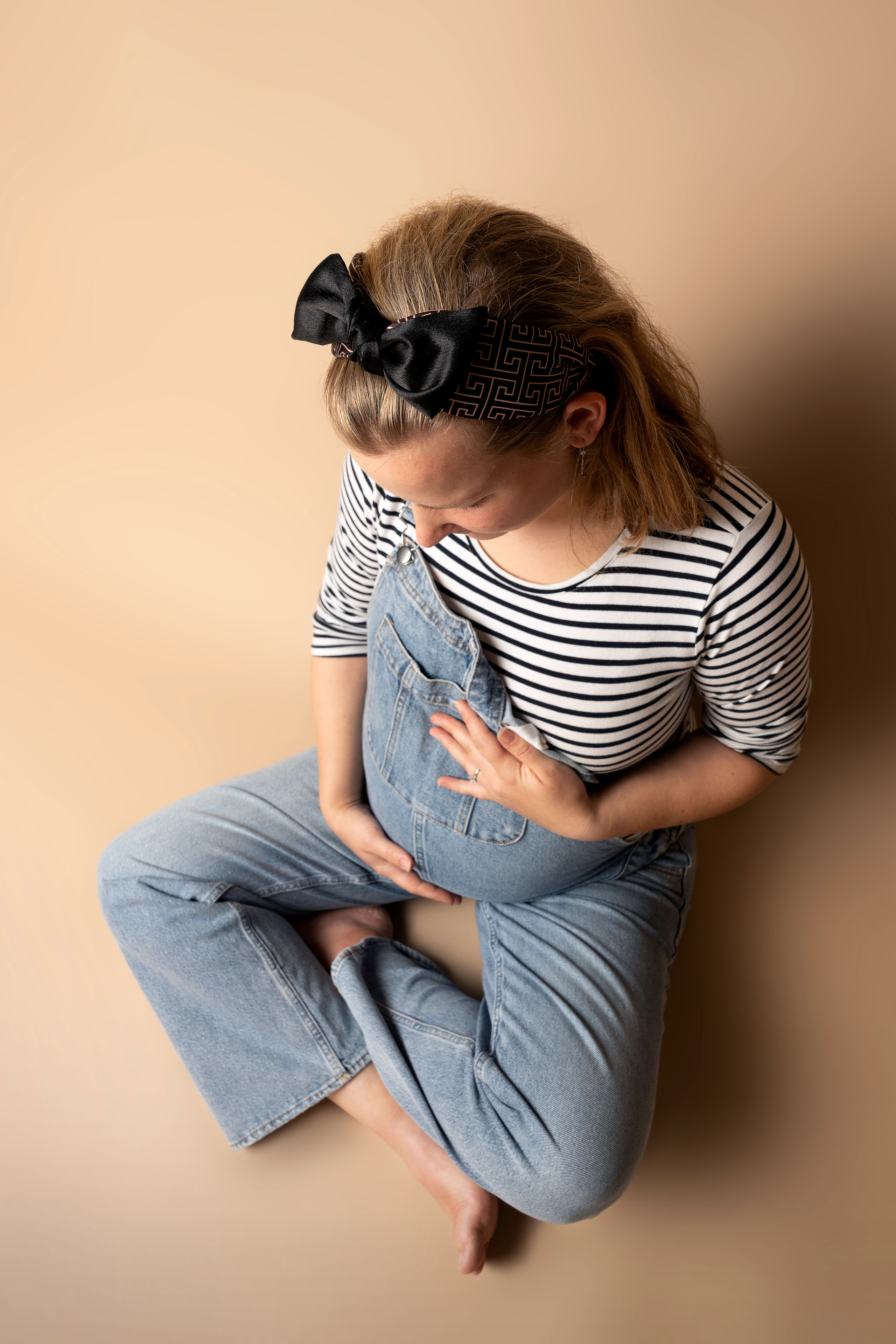 Eine Frau mit babybauch macht Yoga-Übungen am Strand