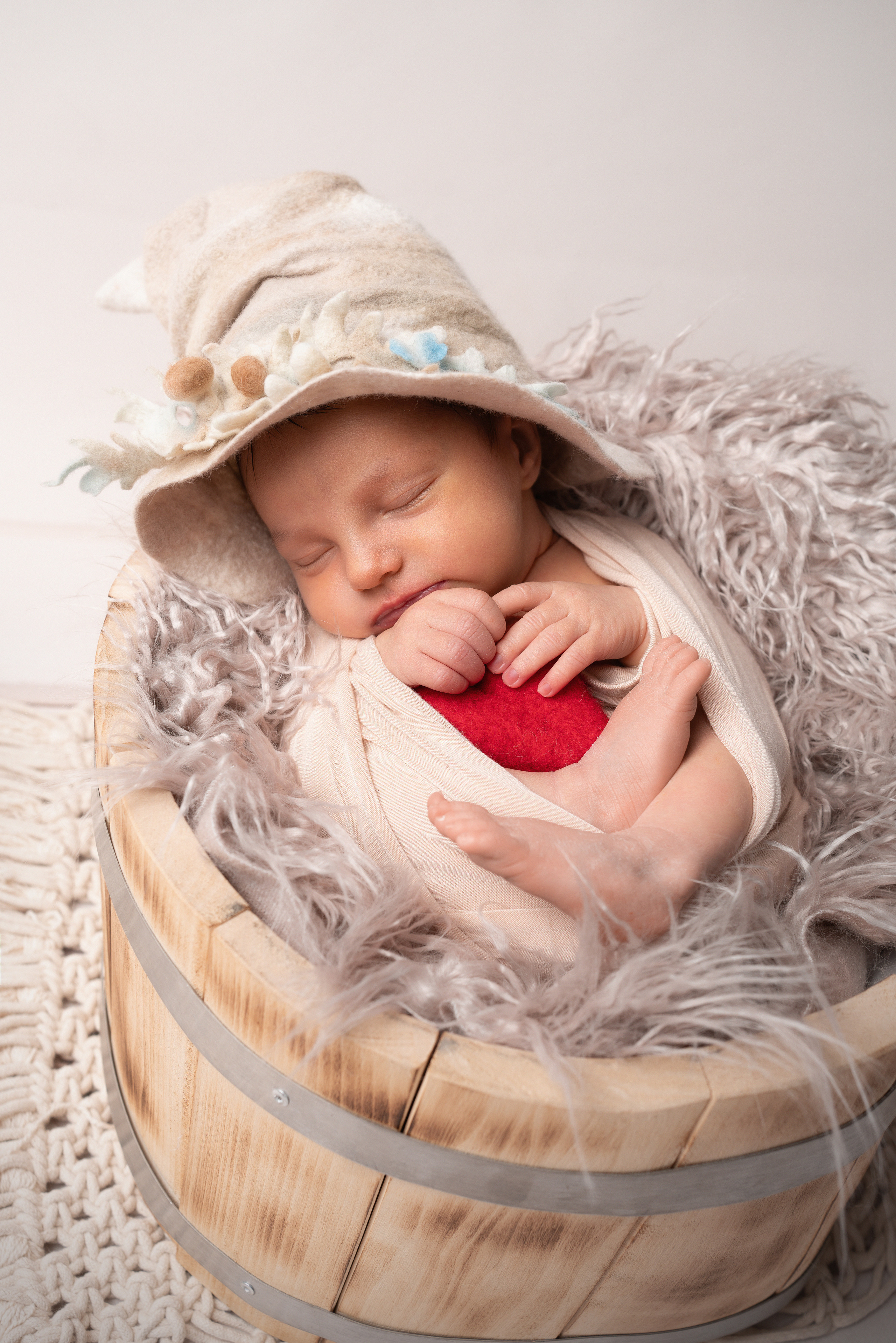 Eine neugeborene Tochter, die in einem süßen Strampler gewickelt ist