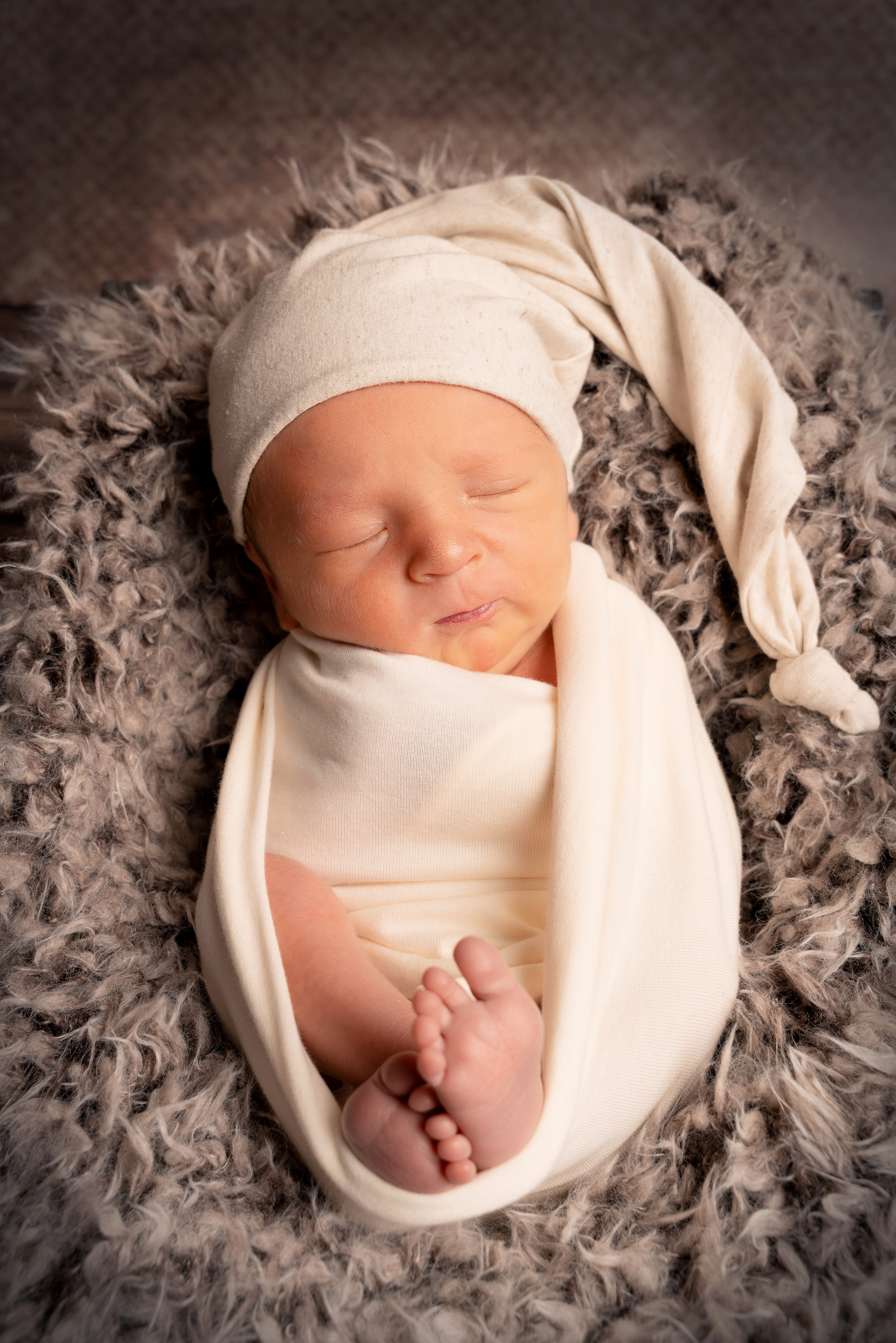 Ein neugeborener Junge hält eine kleine Fliege in seiner Hand
